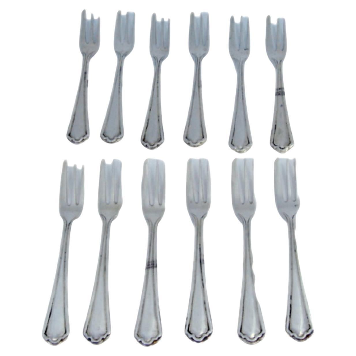 Set of twelve three-pronged silver cake forks with grooves on the handles