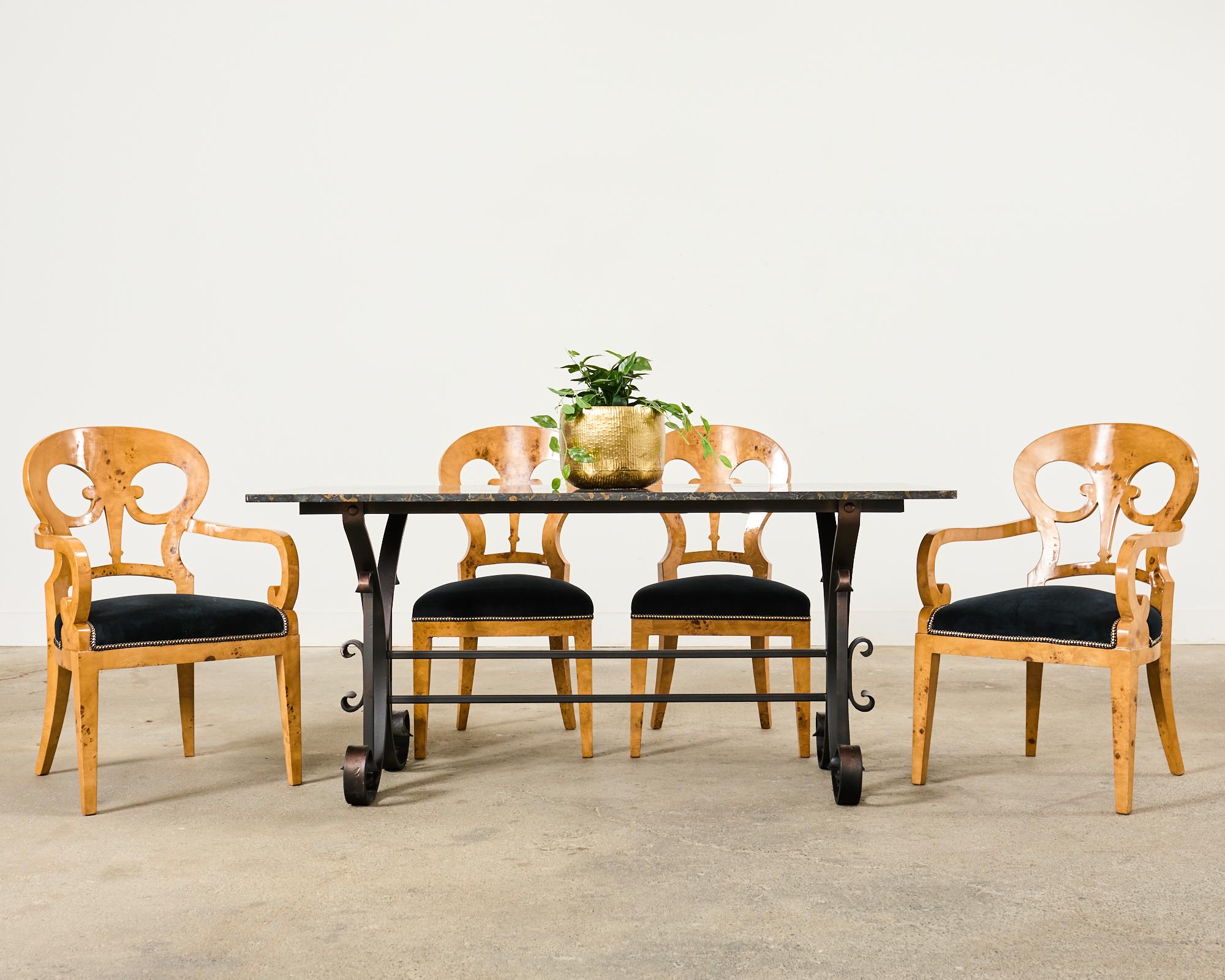 Dramatic set of twelve burl maple root veneer dining chairs made in the Viennese Biedermeier style. The set consists of ten side chairs and two host armchairs measuring 22 inches wide and 22 inches deep. The chairs feature beech wood frames crafted