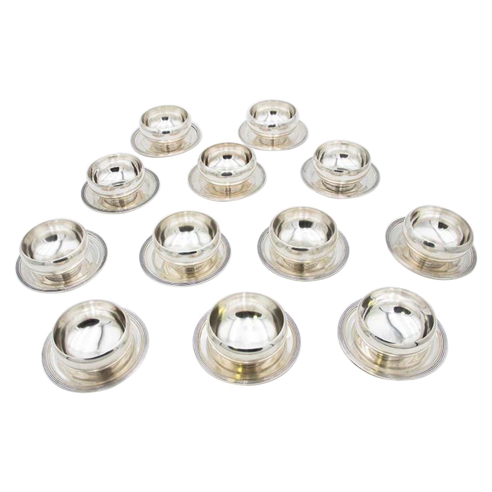 Set of twelve washbasins in smooth silver with beaded reliefs on the bases