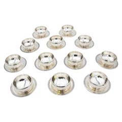 Set of twelve washbasins in smooth silver with beaded reliefs on the bases