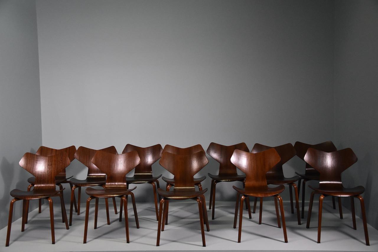 Les chaises sont entièrement en bois et ont été conçues par le designer danois Arne Jacobsen pour la manufacture Fritz Hansen dans les années 1950. Le modèle des chaises est connu sous le nom de Grand Prix.Les chaises d'Arne Jacobsen offrent une