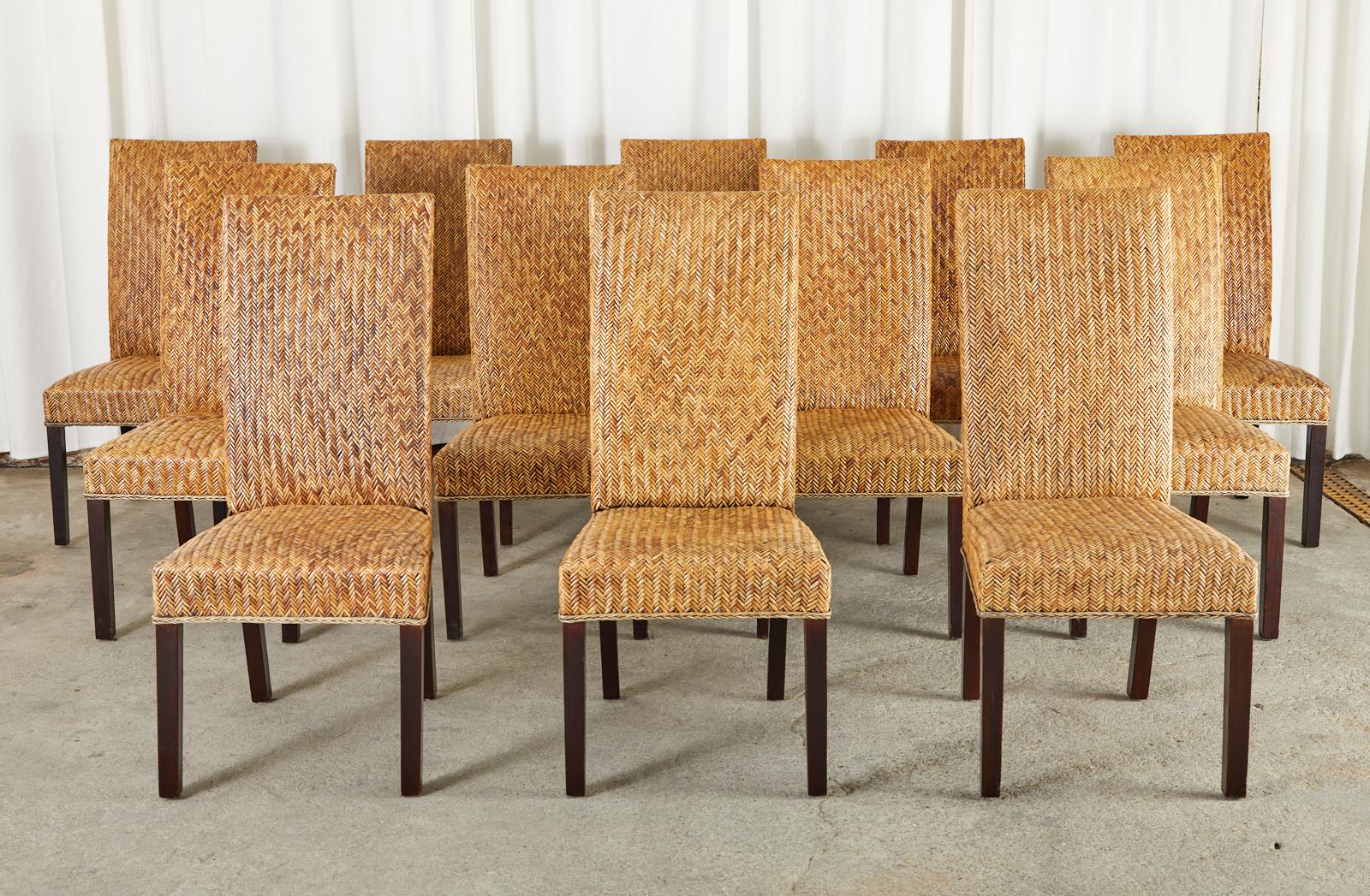 Large set of twenty four gorgeous rattan dining chairs made in the organic modern style. The chairs feature a split rattan woven reed that has a herringbone or chevron design pattern. The frames are constructed of hardwood with a near ebonized