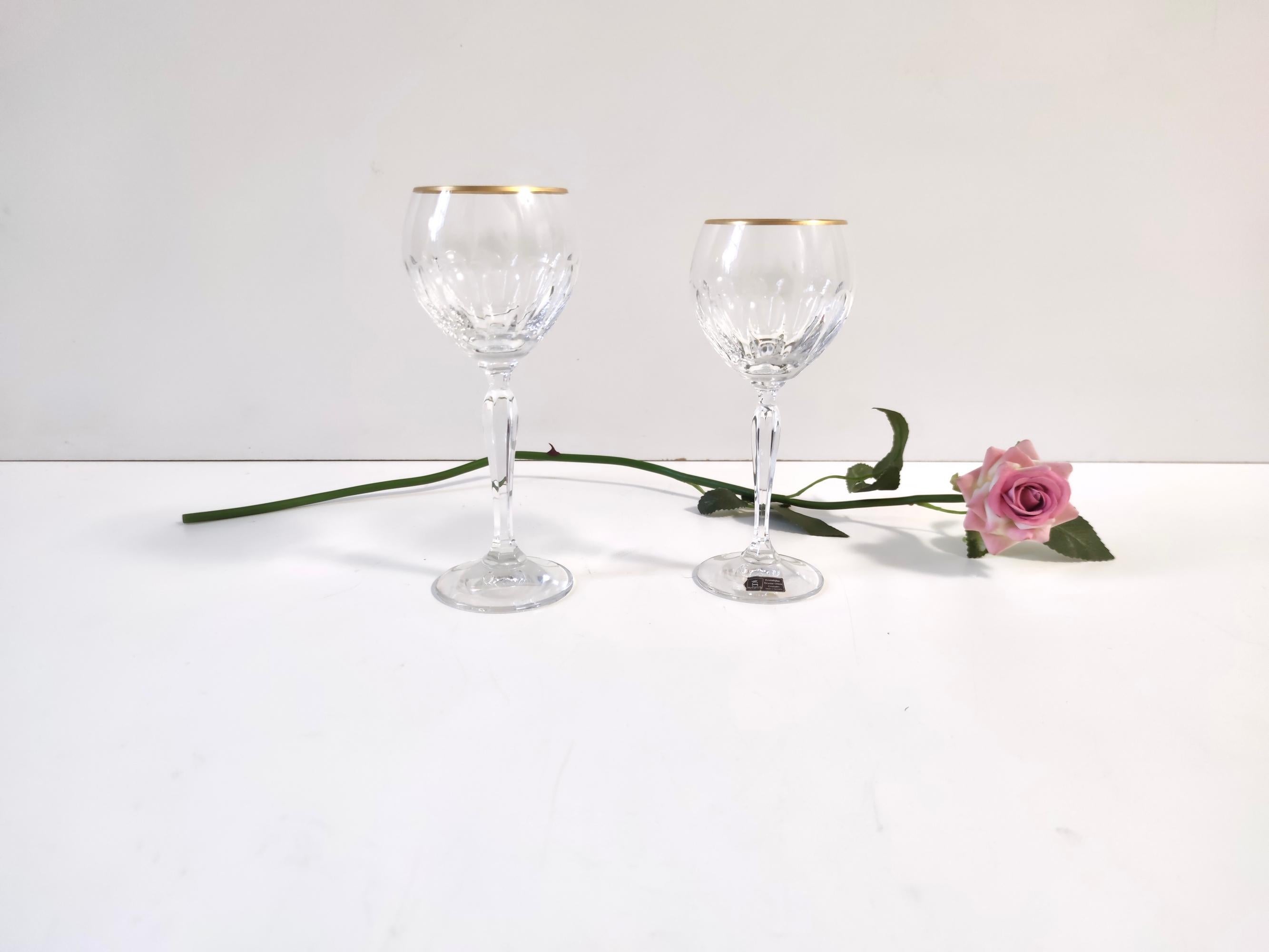 Made in Germany, 1970s. 
This set of twenty-two glasses is made in fine crystal and features a golden rim.
They are produced by Spiegelau, a German company with a centuries-old experience.
It is a vintage set, therefore it might show slight traces
