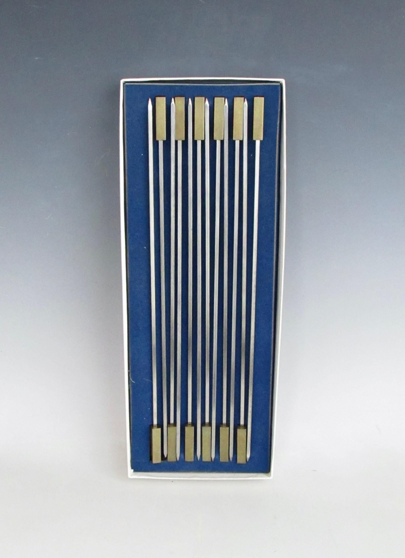 Set of twelve skewers in original somewhat worn box . Rectangular brass handle measures one and 3/8
