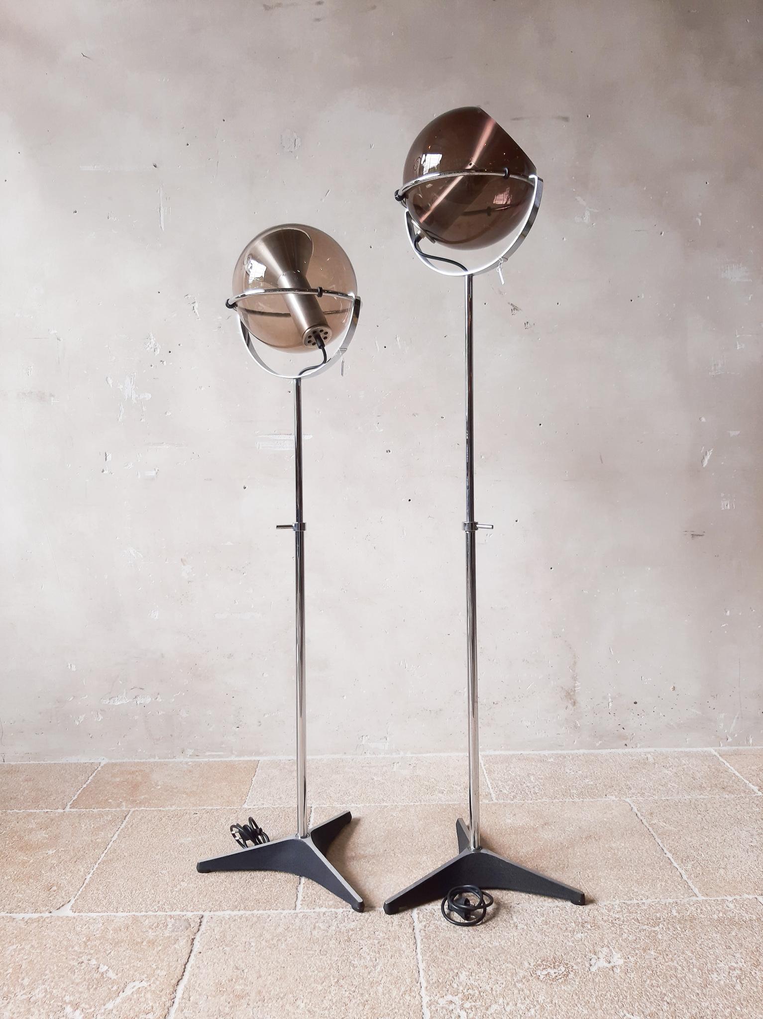 Dutch vintage design classic. The Globe floor lamp by Raak Amsterdam designed by Frank Ligtelijn in 1961. The ball is made of gray/ brown smoke tinted glass and lies in a height-adjustable chrome ring.

35 cm in diameter, maximum height of 125