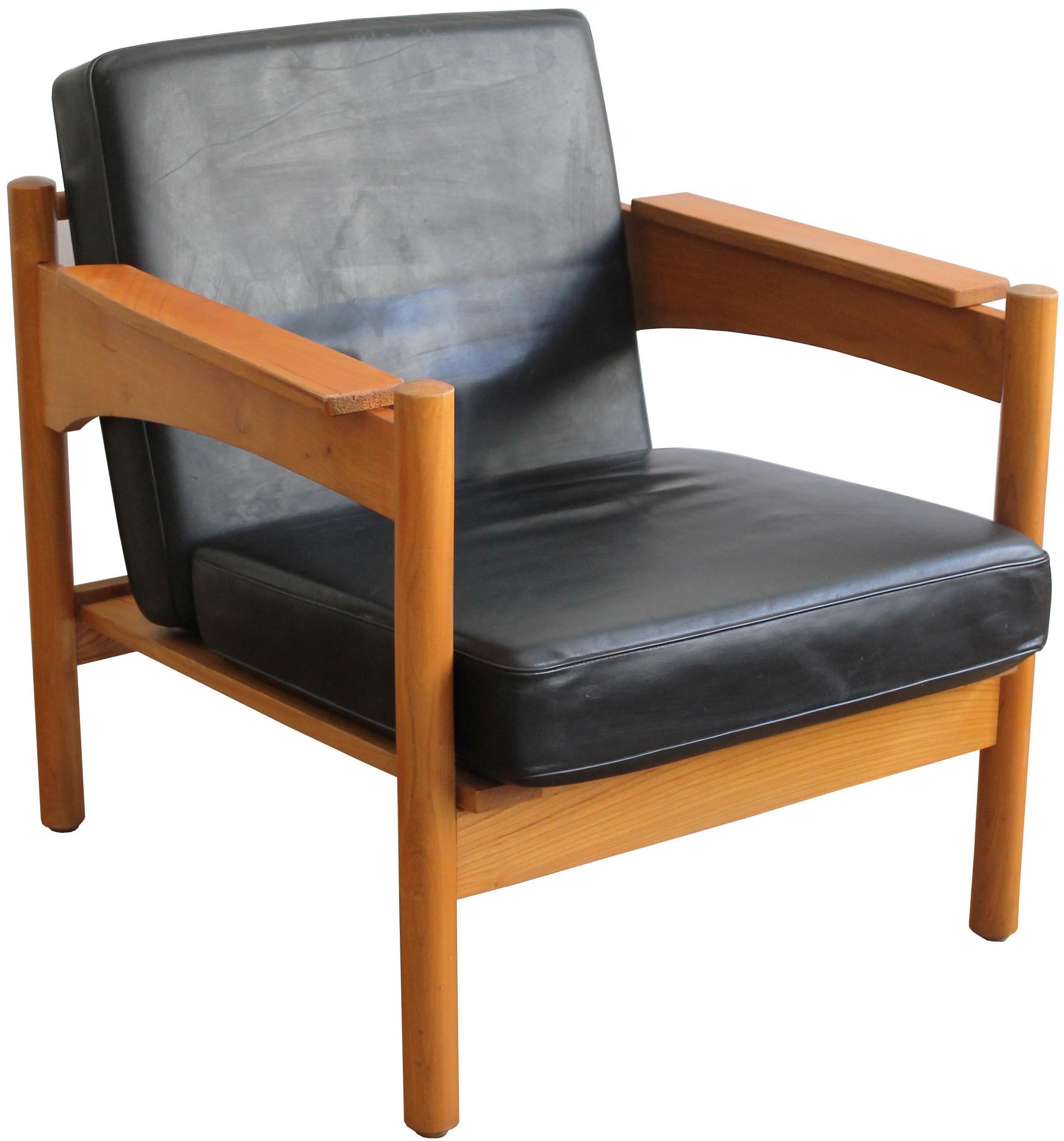 A pair of sleek armchairs from the 1970s.  Made of solid ash, and with its original black leather cushions, these armchairs were made in the Czechoslovakian communist era as luxurious items. It was almost impossible to buy them, they were used