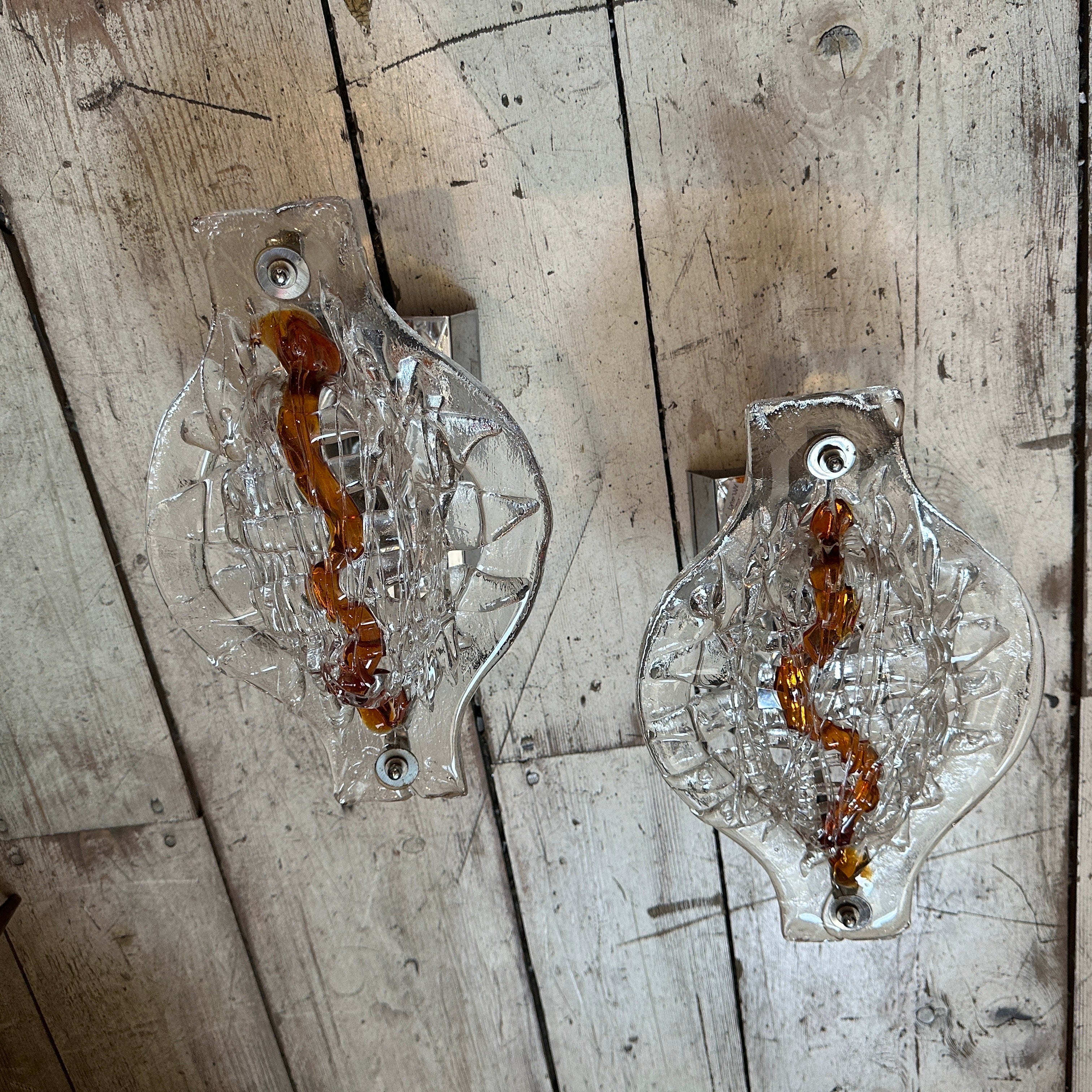 Queste appliques di Mazzega non sono semplici apparecchi di illuminazione, ma pezzi unici che mostrano la fusione di arte e utilità che caratterizza l'artigianato del vetro di Murano. La loro miscela di design audace dell'era spaziale e di elementi