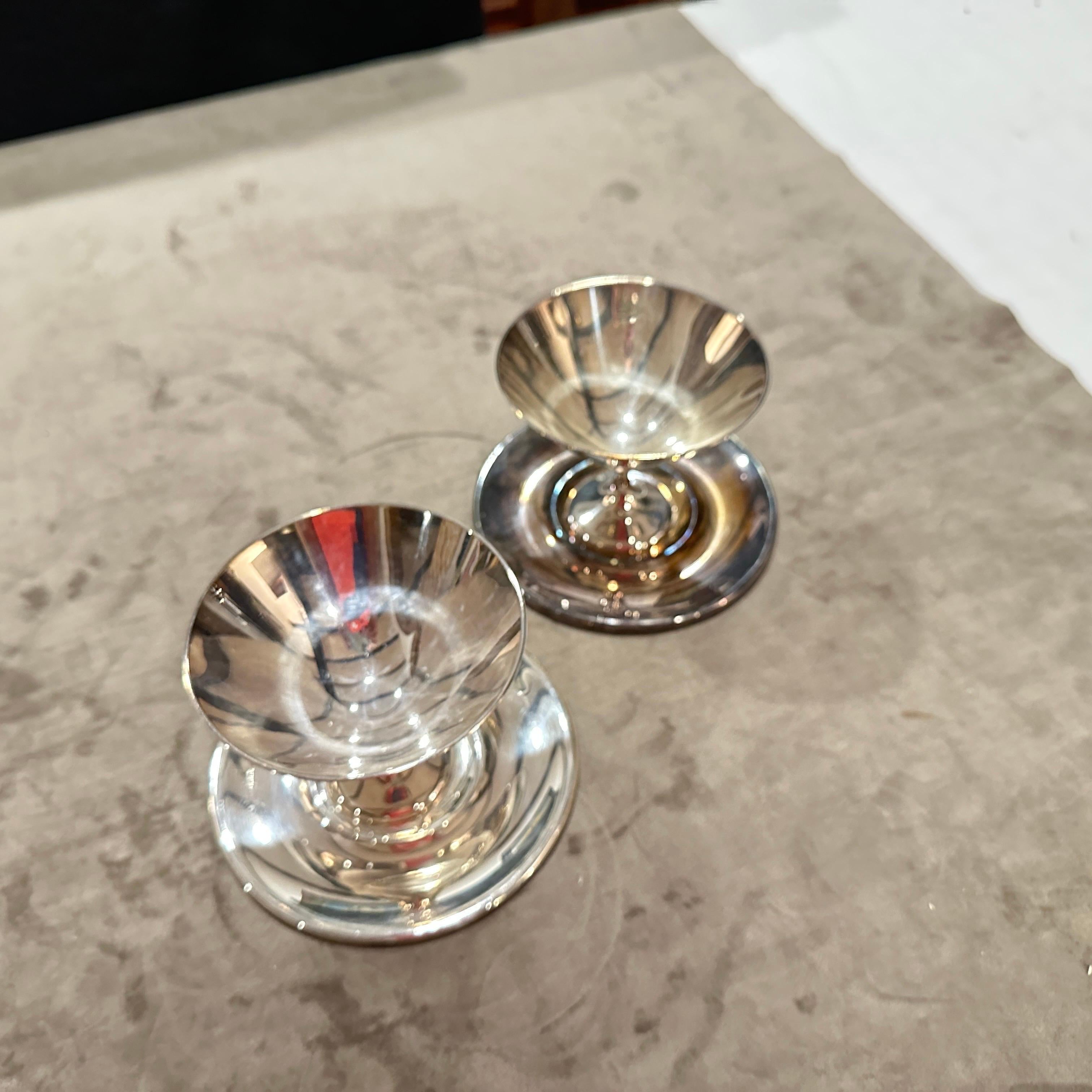 A set of two modernist silver-plated cups and matching plates, designed by the renowned Italian designer Lino Sabattini. A perfect representation of post-war Italian design, this set embodies the sleek, minimalist aesthetic Sabattini is celebrated
