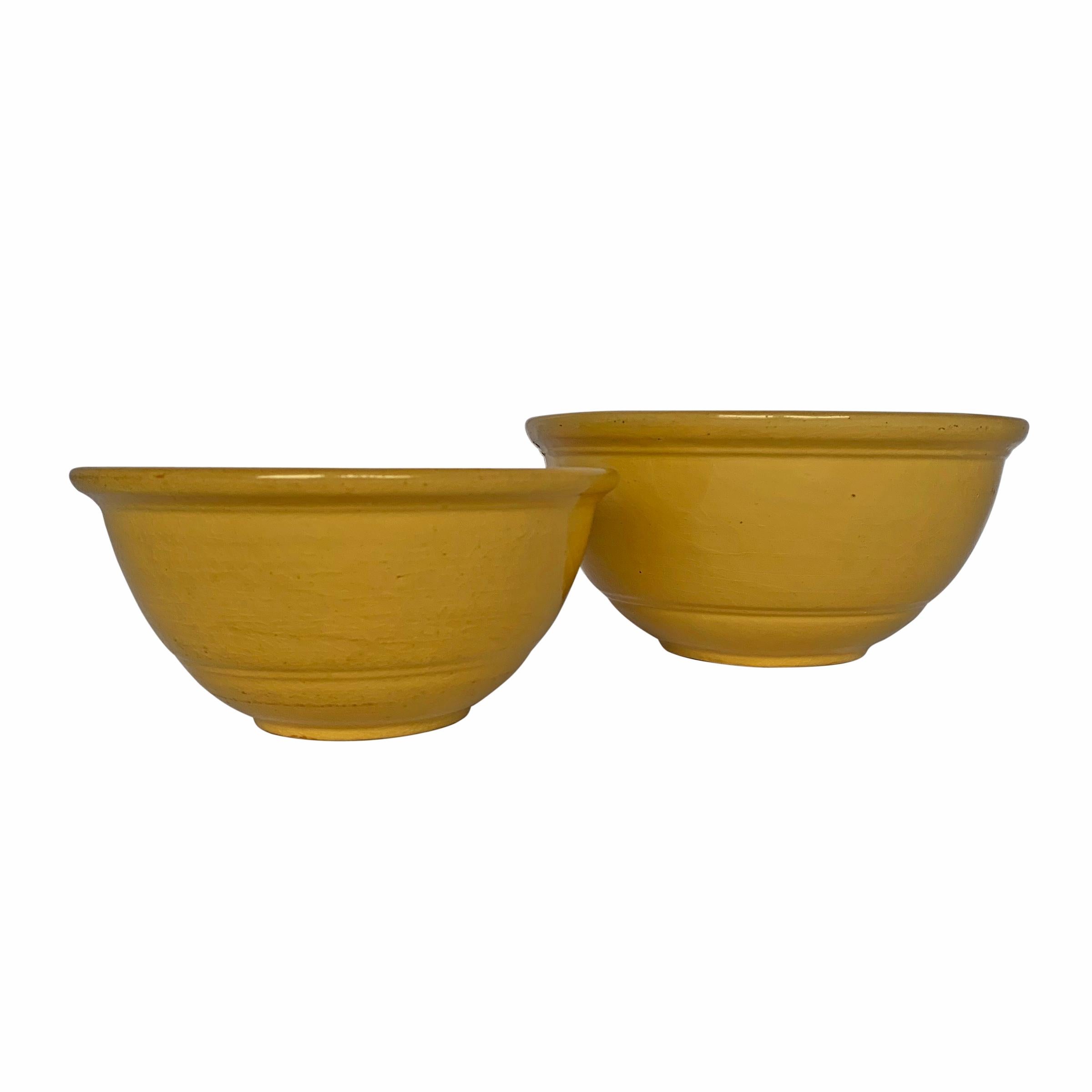 A set of two late 19th century American yellow ware mixing bowls of graduated sizes with simple incised lines at various points.

Measures: Small 8.25 in. diameter x 4 in. height.
Large 10.5 in. diameter x 4.75 in height.