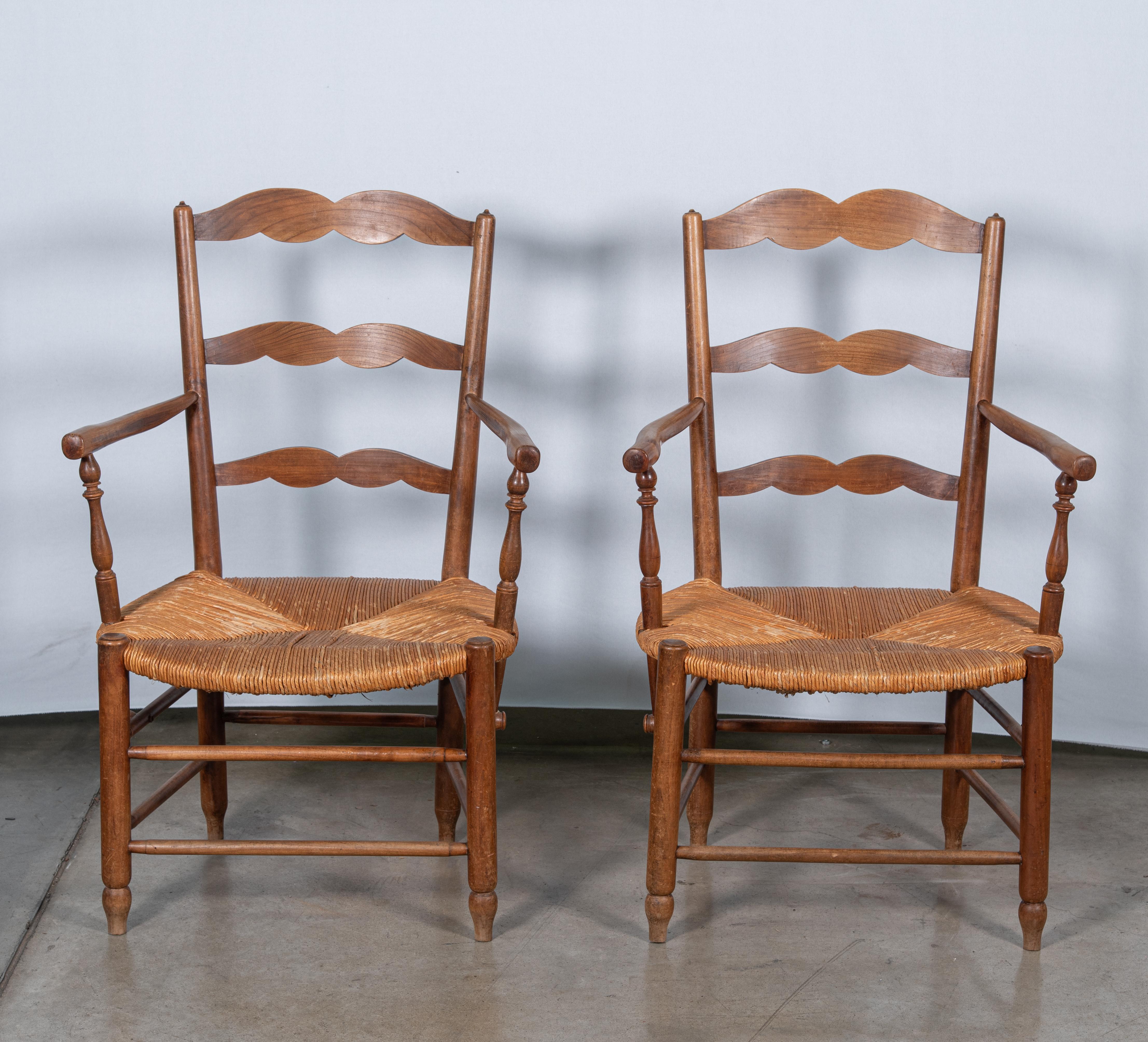 Unser Set aus zwei Sesseln im französischen Landhausstil des 19. Jahrhunderts, die sorgfältig aus haltbarem Eichenholz und geflochtenem Rattan gefertigt sind, verleiht Ihrem Zuhause einen rustikalen Charme. Diese Stühle, die die Essenz des