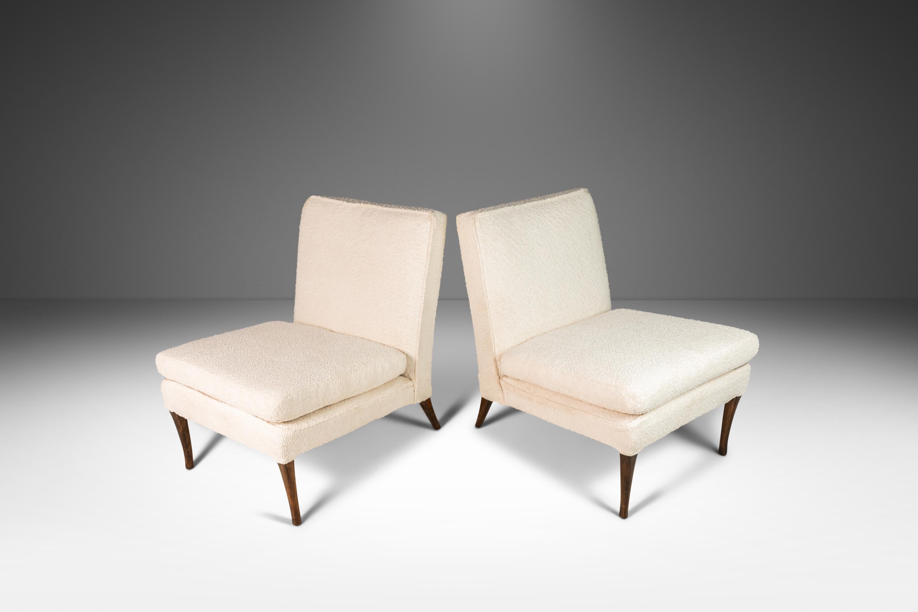 The epitome of 1950's modern design, these two armless chairs have been attributed to T. H. Robsjohn-Gibbings for Widdicomb and are newly upholstered in Knoll Fabrics White Boucle. Their iconic shape and classic lines make them instantly