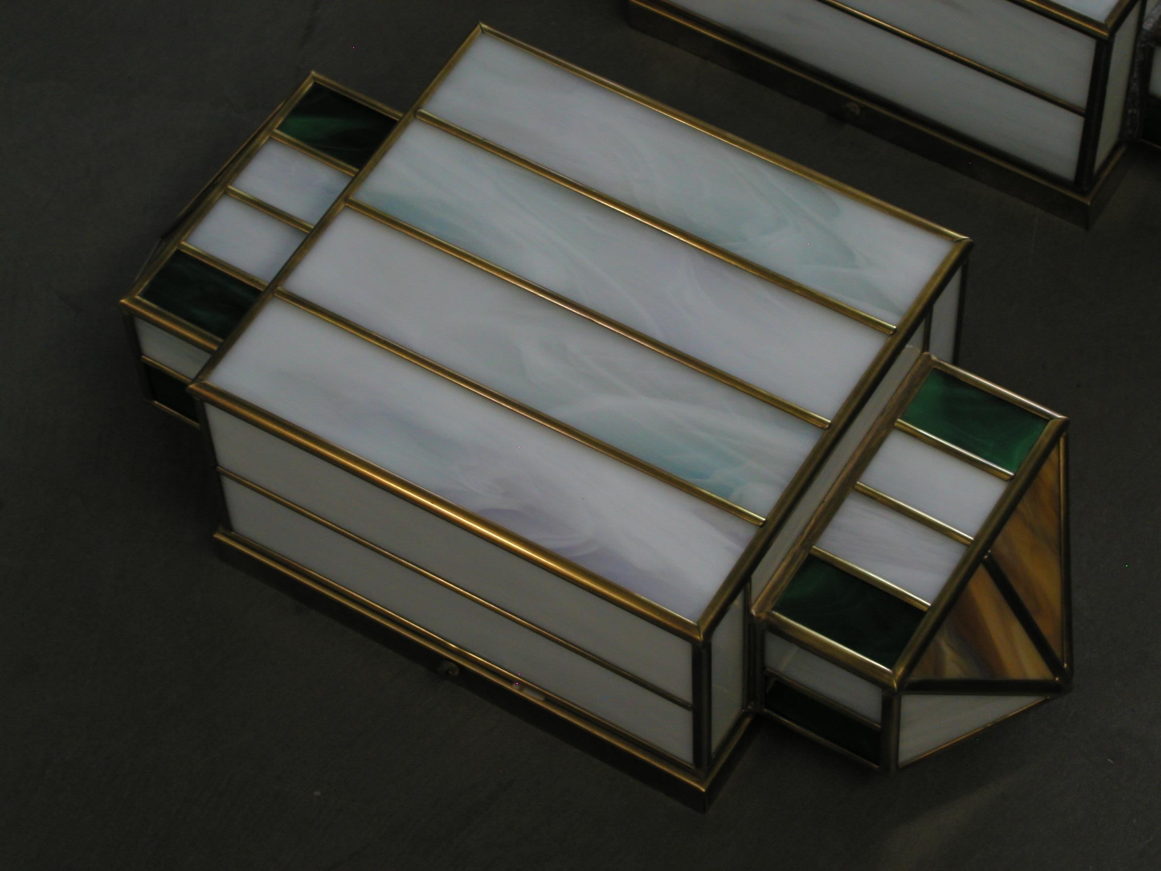 Ensemble de deux appliques en verre de Murano et laiton fabriquées dans les années 80 par des artisans italiens.
Fabriquées artisanalement avec du verre de Murano brun, vert et blanc et du laiton, ces magnifiques pièces incarnent parfaitement