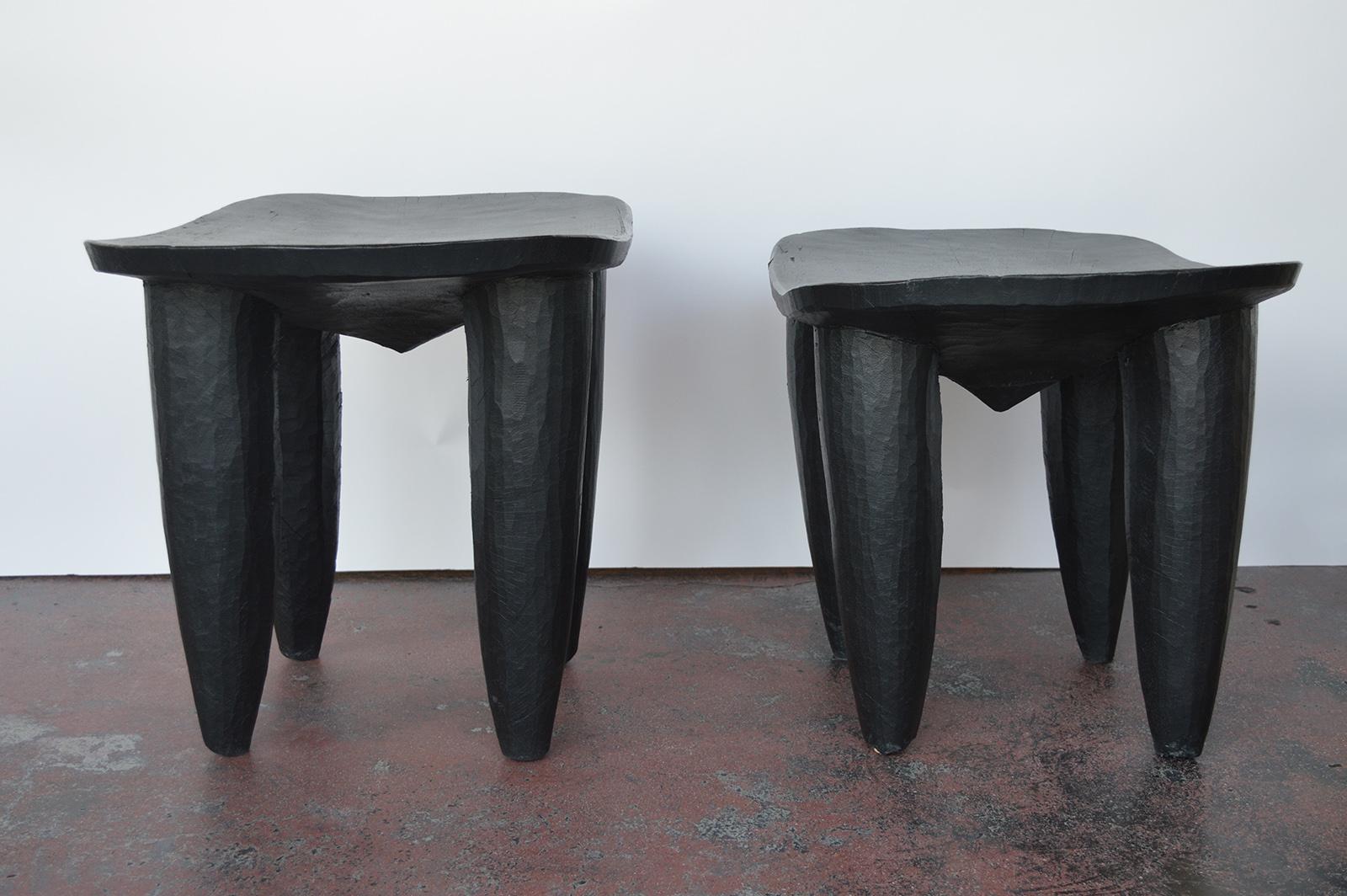 Two hand-carved wood side tables or stools, painted black.
Smaller stool measures, 18 inches H x 24 inches W x 17.5 inches D.