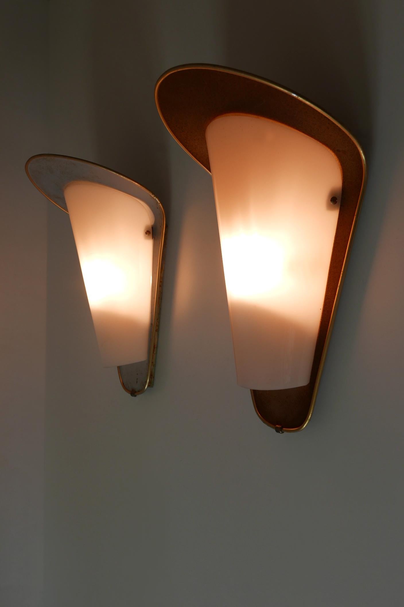 Set of two rare, elegant and highly decorative Mid-Century Modern outdoor sconces or wall fixtures. Designed & manufactured in Germany, 1950s.

Executed in metal and lucite, each sconce is executed with 1 x E27 / E26 ceramic Edison screw fit bulb
