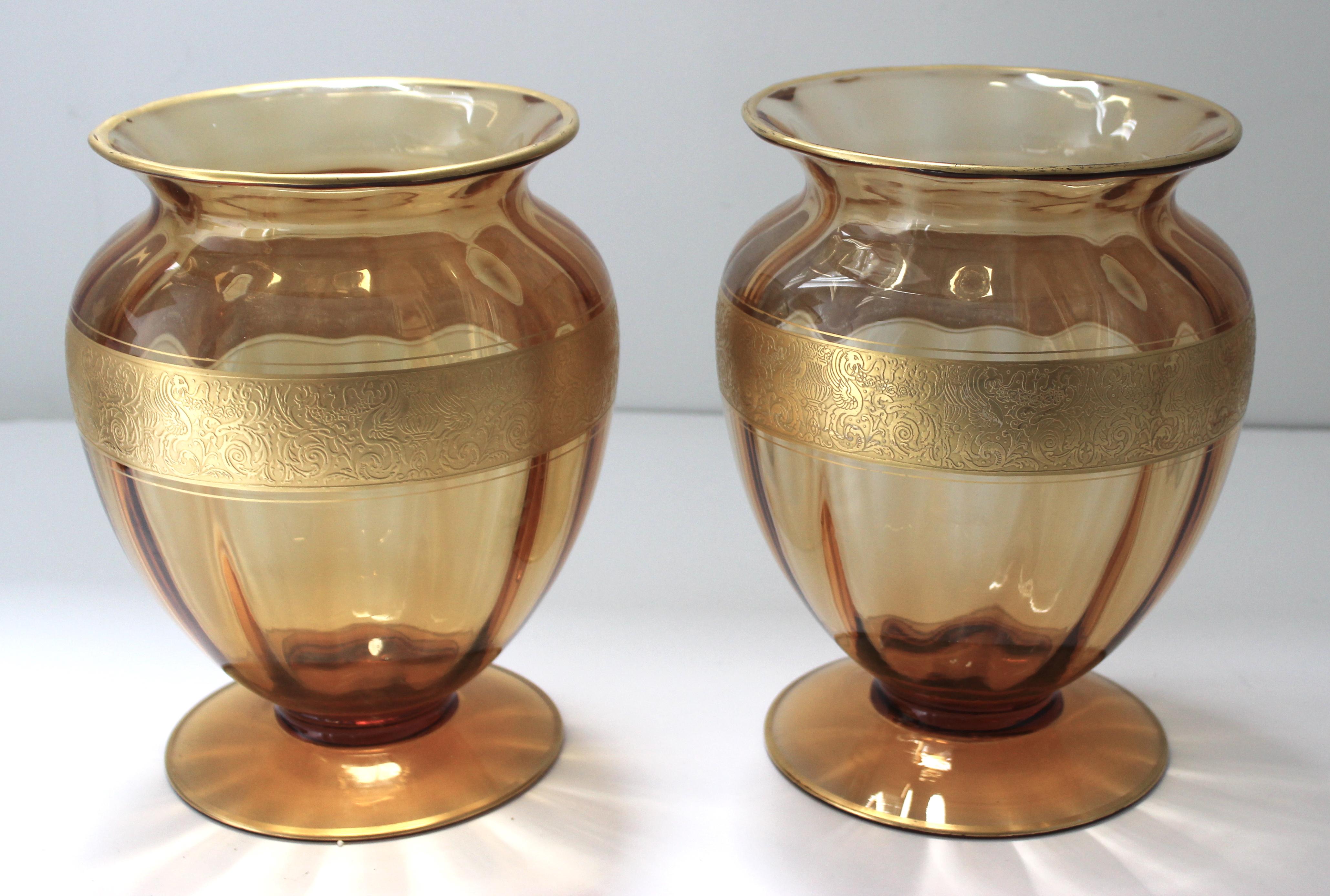 This large scale and stylish pair of Moser Glassorks vases date to the late 1930s-1940s and were acquired from a Palm Beach estate. The golden coloration catches the light beautifully as does the gilt gold band and edges. The band is detailed with