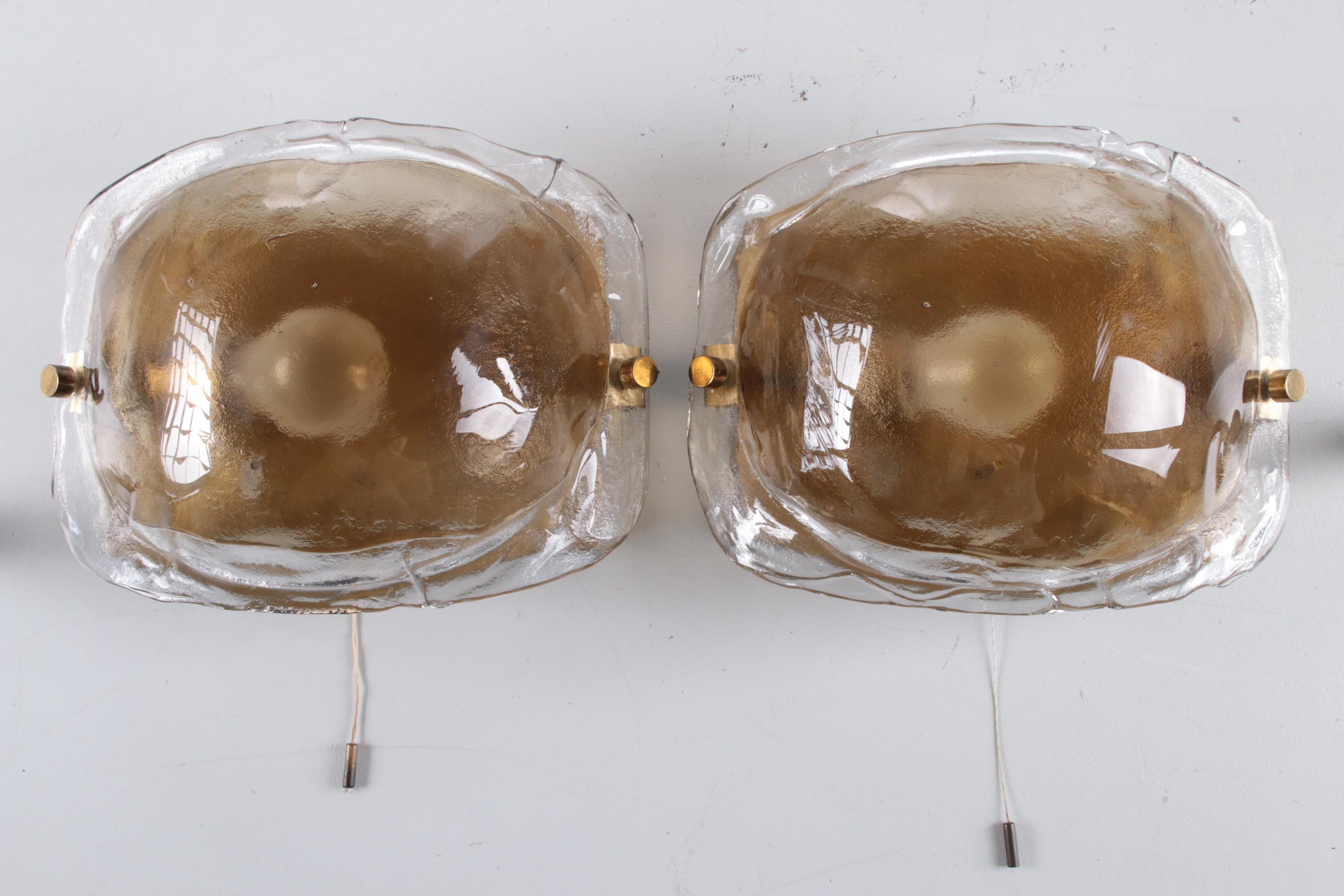 Set of two amber wall lamps in murano glass by Kaiser Leuchten

A pair of beautiful 1970s wall lamps in Murano glass with brass detail by Kaiser lighting.

The thick glass shades emit a warm diffused amber light.

The organic quality of the