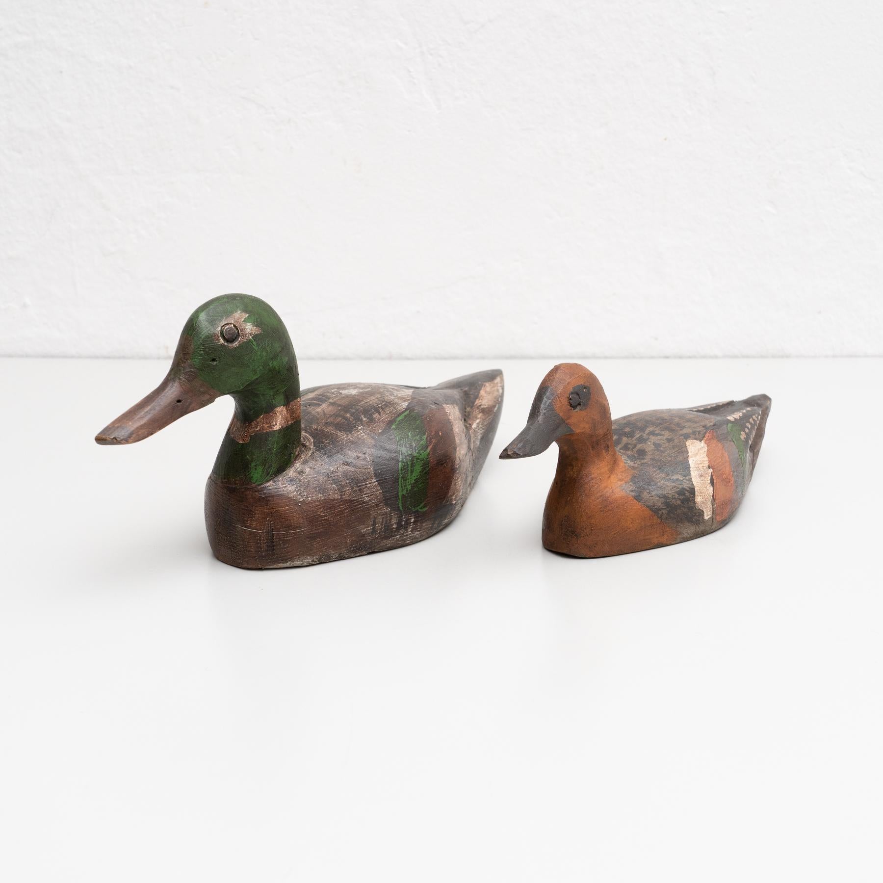 Set di due figure antiche di due anatre dipinte a mano e realizzate in legno.    Realizzato da un produttore sconosciuto a Barcellona, Spagna, intorno al 1950.    In condizioni originali, con lievi usure dovute all'età e all'uso, che conservano una
