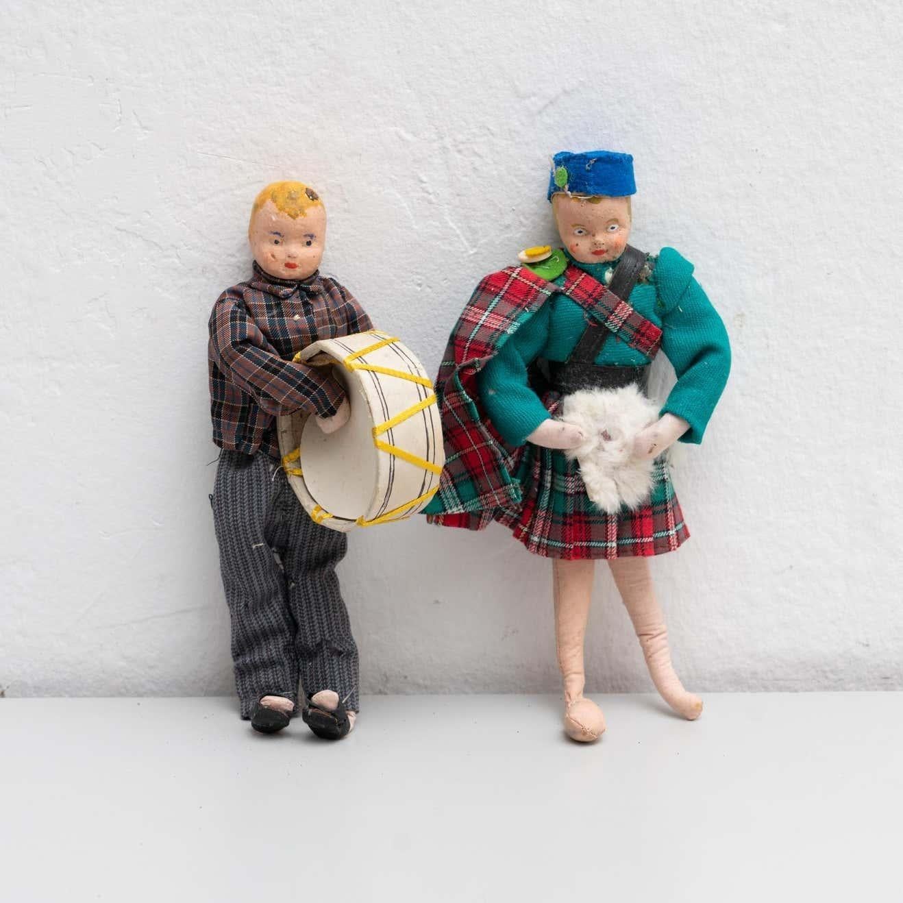 Muñeca de trapo antigua de principios del siglo XX, pintada a mano, de dos hombres vestidos con trajes folclóricos. Ambas muñecas presentan una prenda tradicional escocesa acolchada.  Fabricada hacia 1920 en España.  En su estado original, con