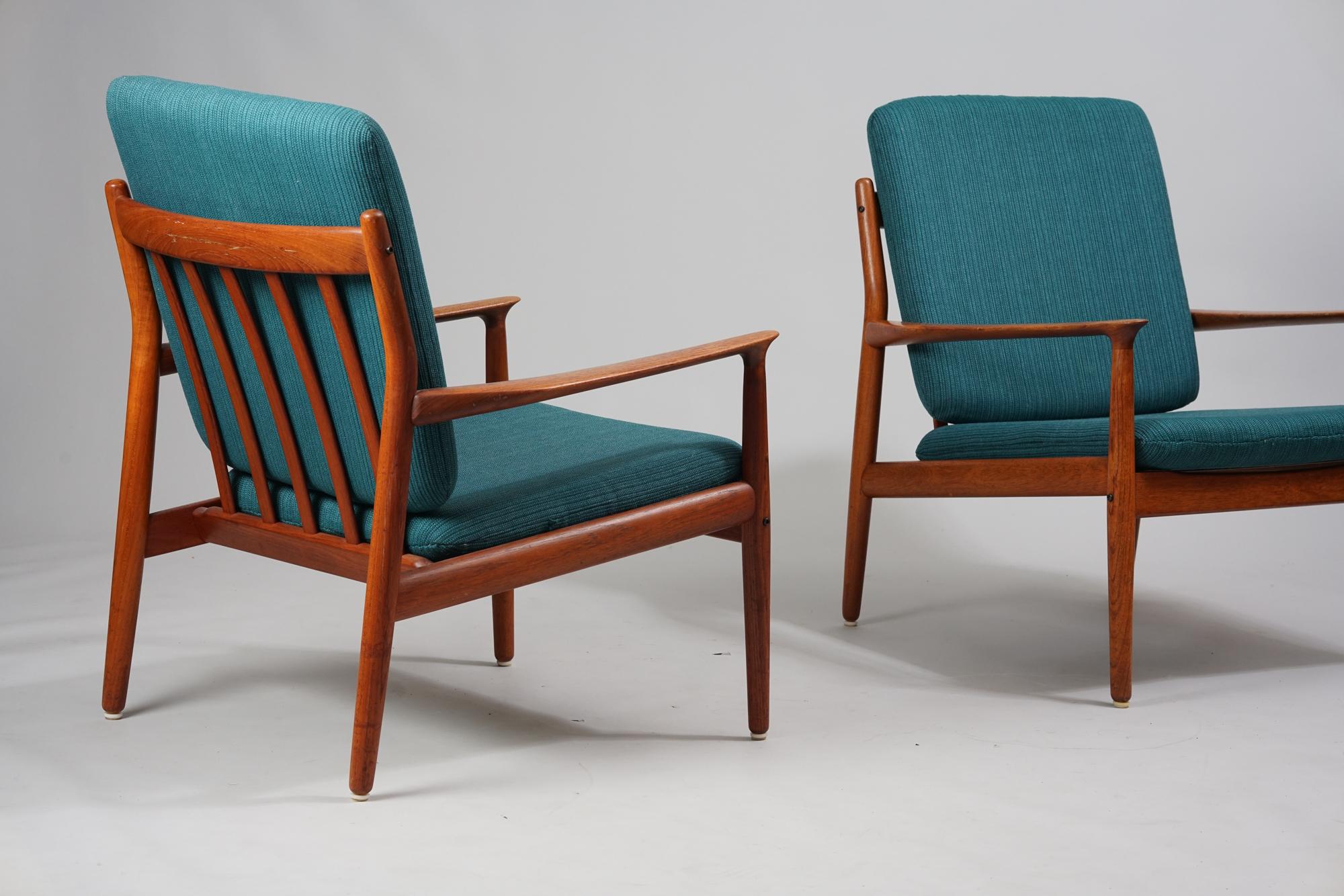 Set of two armchairs by Grete Jalk from the 1960s. Teak frame with fabric upholstery. Good vintage condition, minor wear and patina consistent with age and use. The armchairs are sold as a set. 

Recognized as an important Danish modernist