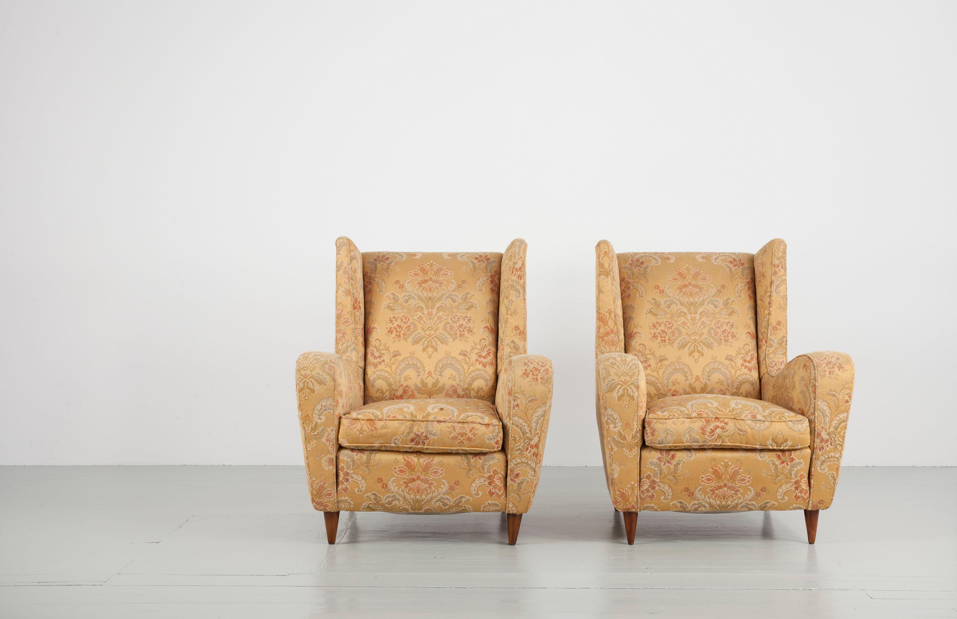 Set of two armchairs designed by Melchiorre Bega. These elegantly proportioned wingback chairs feature tapered walnut legs and are upholstered in their original fabric in a golden colour and with ornamentals.

Feel free to contact us for more