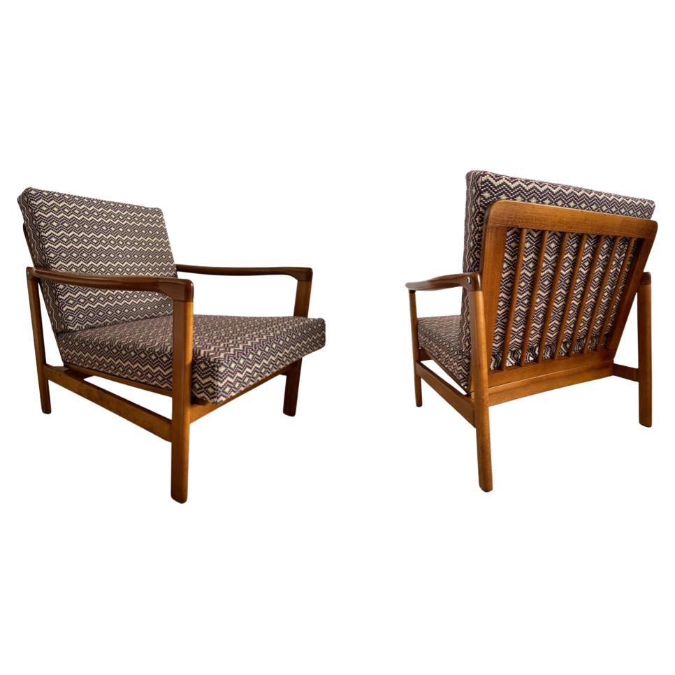 Das Set aus zwei Sesseln, Modell B-7752, entworfen von Zenon Baczyk, wurde in den 1960er Jahren von Swarzedzkie Fabryki Mebli in Polen hergestellt. 

Die Struktur besteht aus Buchenholz in tiefem Honigbraun, das mit einem seidenmatten Lack