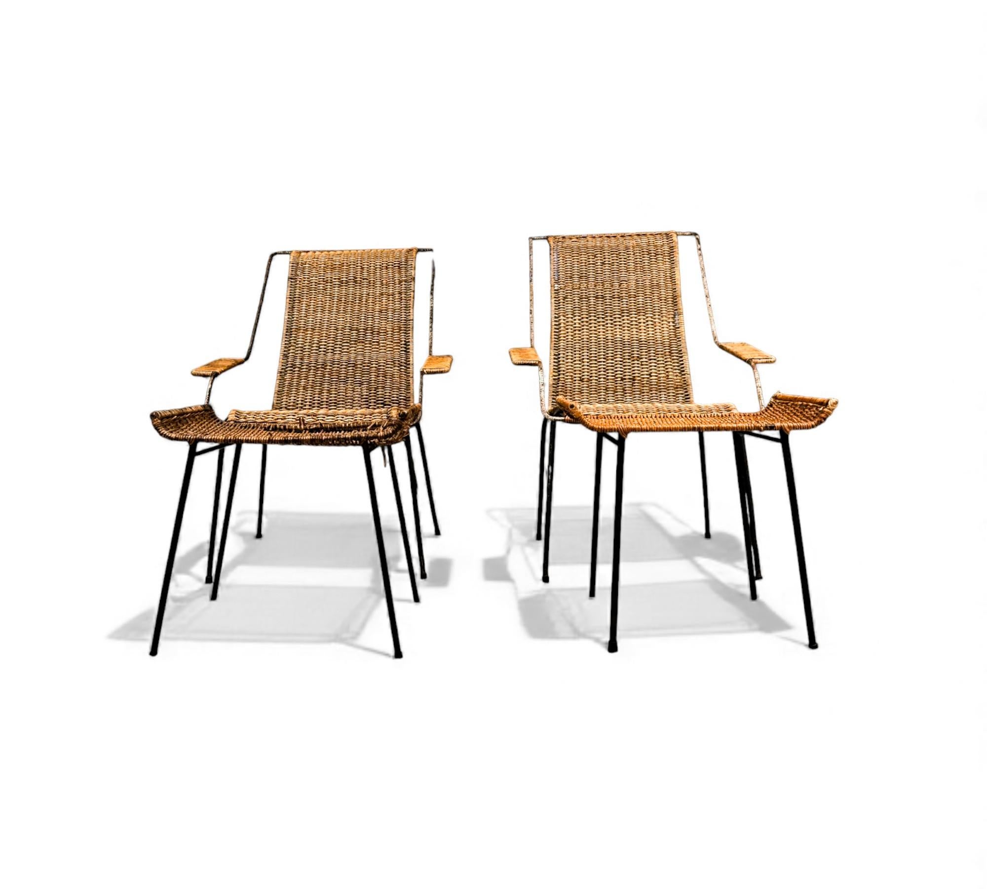Designed by Carlo Hauner in the 1950s, these two armchairs feature an iron structure with four slender legs, a tall backrest, a curved seat, and wide armrests—all finished in handwoven caning. Each chair is paired with a matching stool, and all four