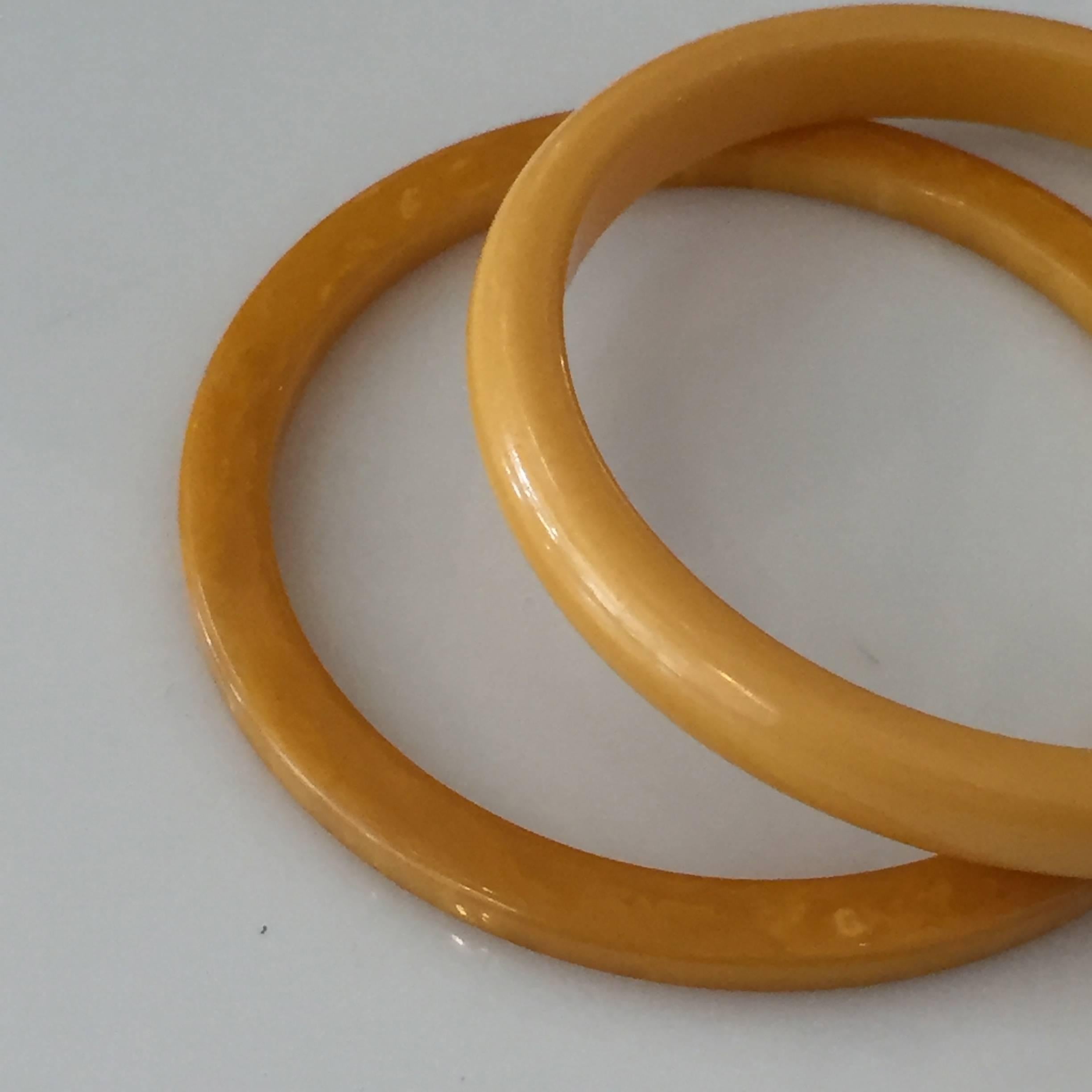 Set of two Art Deco butterscotch amber-colored Bakelite bracelets.
One bangle is a square style design at 2 3/8