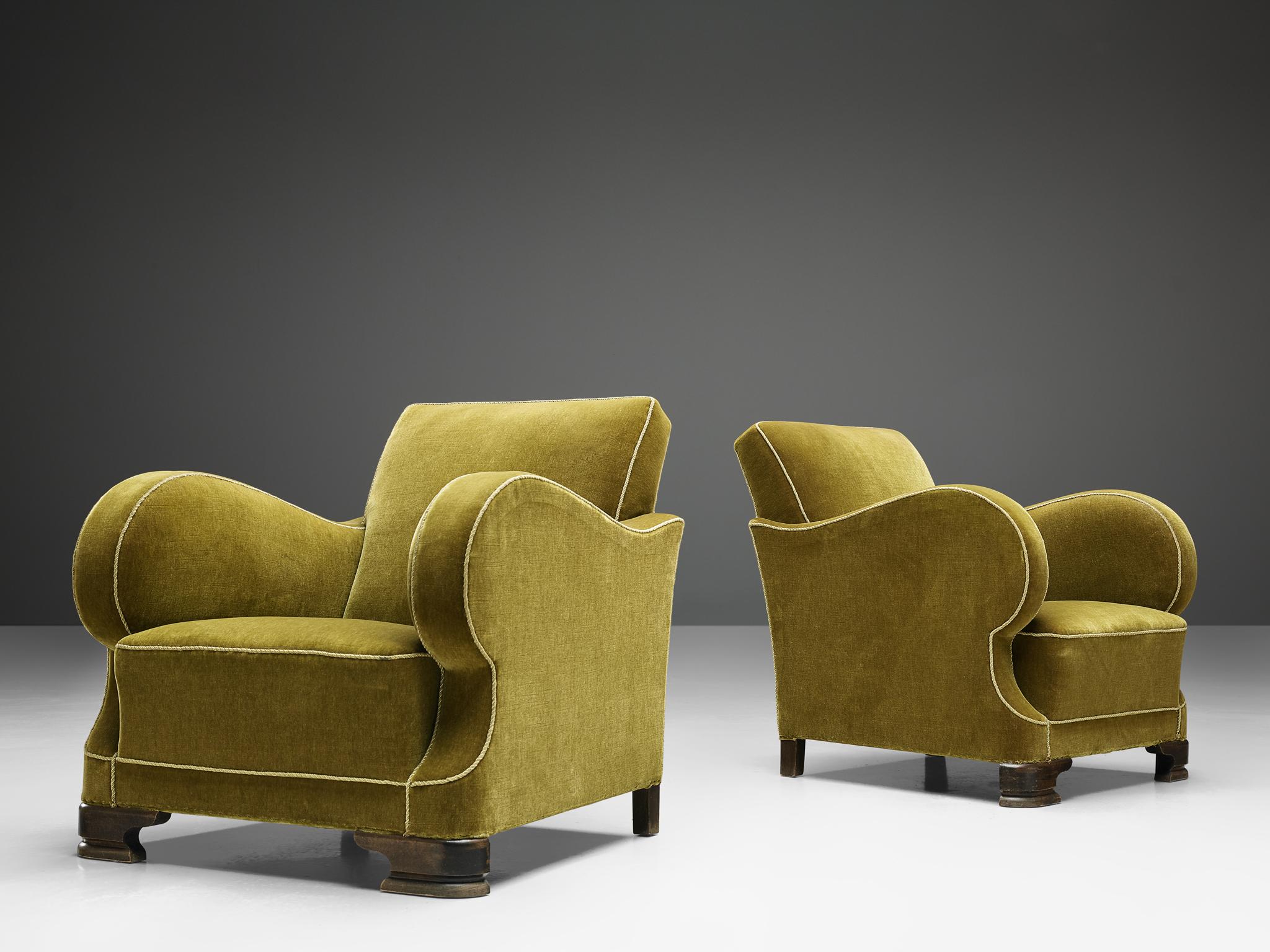 Set of two armchairs, in wood and velour, France, 1930s. 

Impressive pair of 1930s Art Deco lounge chairs, in original green velour upholstery and a variety of well-designed lines and stunning details. These voluptueus chairs with rounded arms en