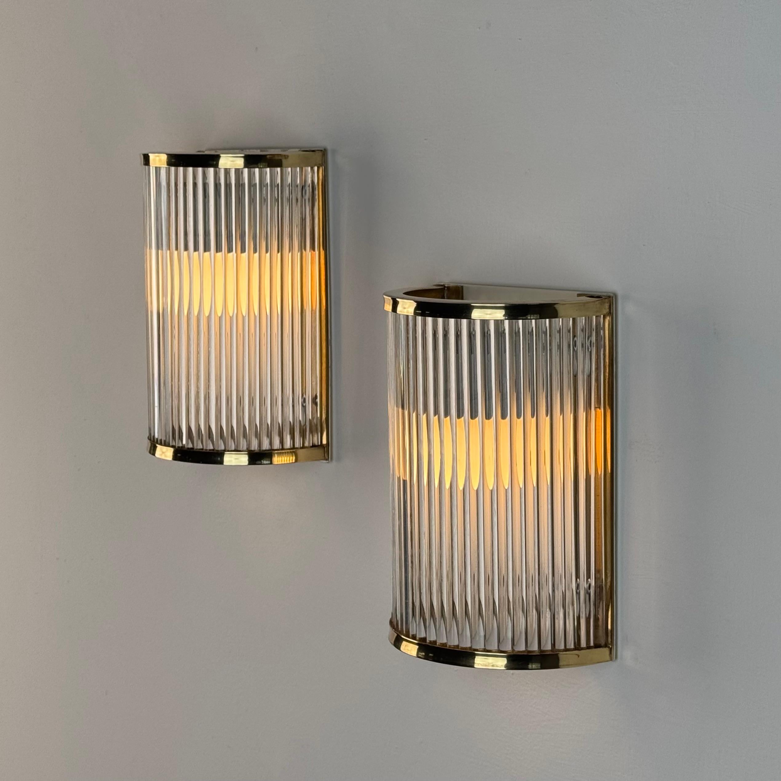 Una raffinata coppia di applique in vetro di Murano e ottone lucido di De Majo, Venezia, prodotte negli anni Settanta. Eleganti e senza tempo, questi pezzi reinterpretano magnificamente il fascino dell'Art Déco degli anni '30 attraverso la maestria