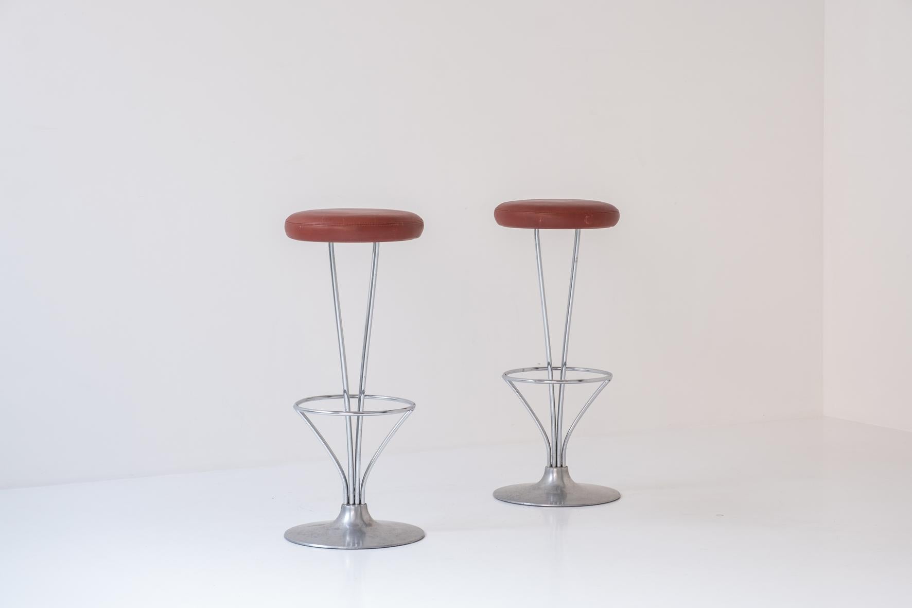 Lovely set of two bar stools by Piet Hein for Fritz Hansen, Denmark, 1960s. These stools have chrome-plated frames and a brushed aluminum base with its original leather upholstery. One of the best modern bar stool designs of the 20th century.