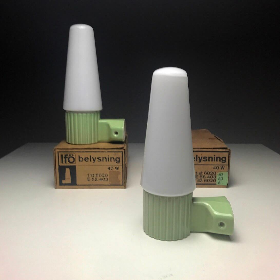 Soft mint green glazed porcelain combined with cone shaped milky white opaline glass is just a beautiful Scandinavian midcentury design by Sigvard Bernadotte for IFÖ, Sweden 1960s. 

This set of two sconces are completely “new old stock” and have