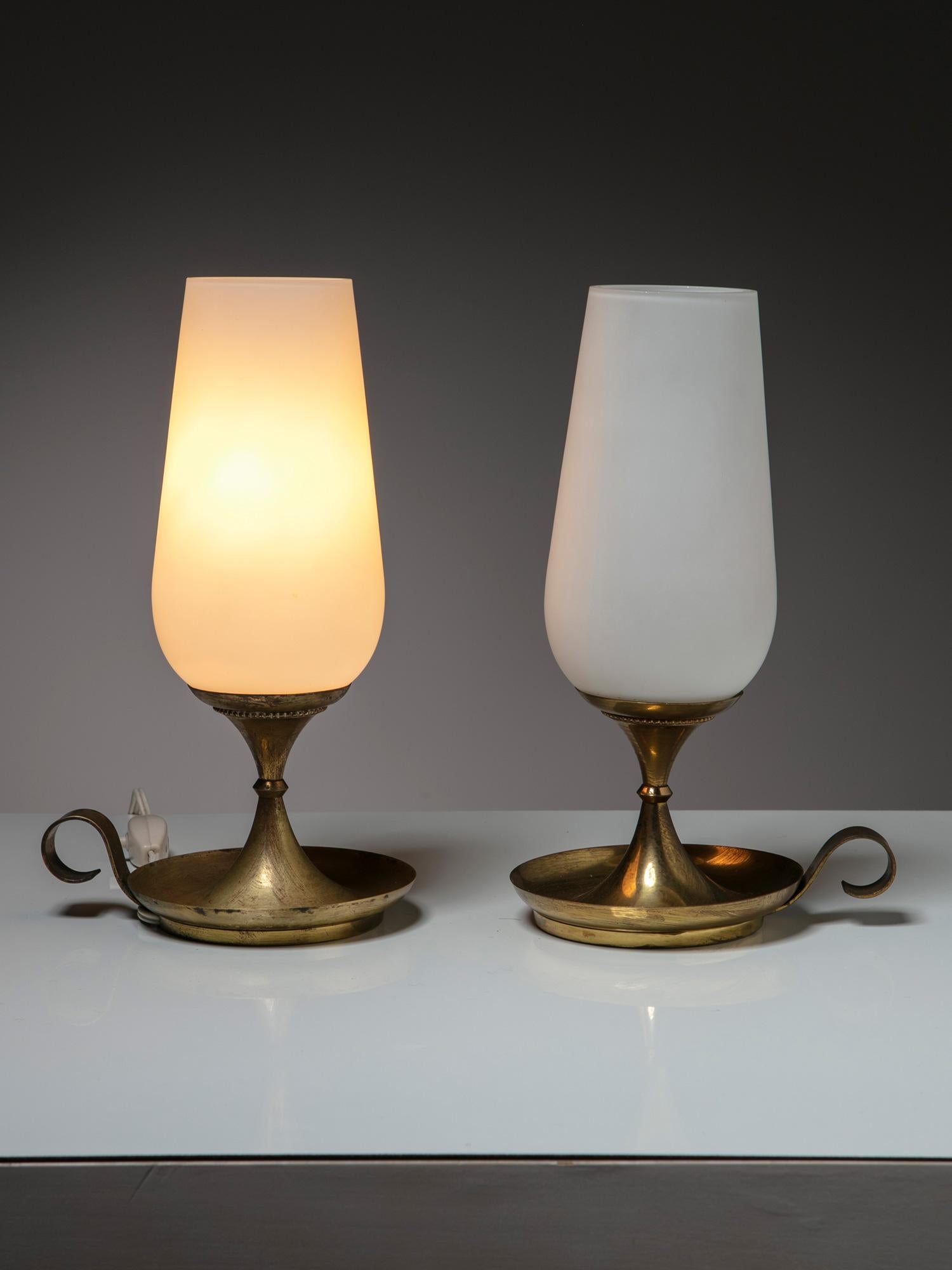 Rare paire de lampes de chevet fabriquées par Stilnovo.
Abat-jour en verre à double couche et base épaisse en laiton.