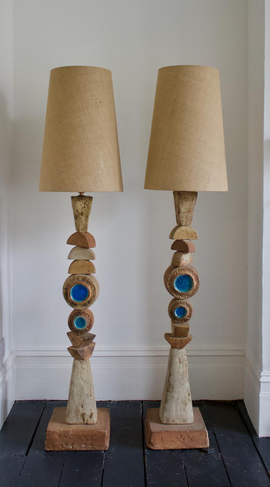 A set of two monumental ceramic TOTEM floor lamps by Bernard Rooke, England, 1960s.

Beautiful sculptural pieces of Studio Pottery, made up of ceramic elements in natural tones of terracotta and stone. The round elements are decorated on one side