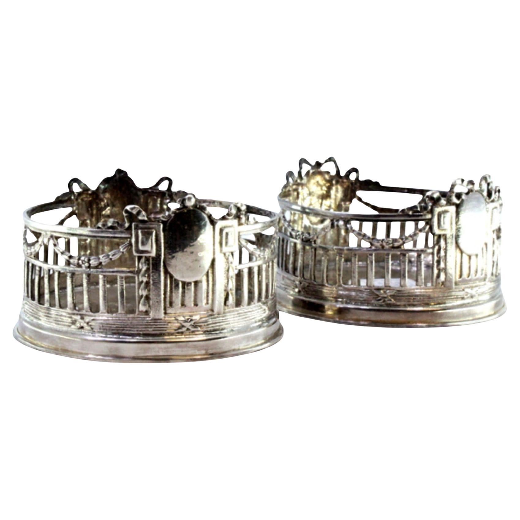 Set of two bottle bottoms in cut silver w/ monogram cards 
surrounding strips For Sale