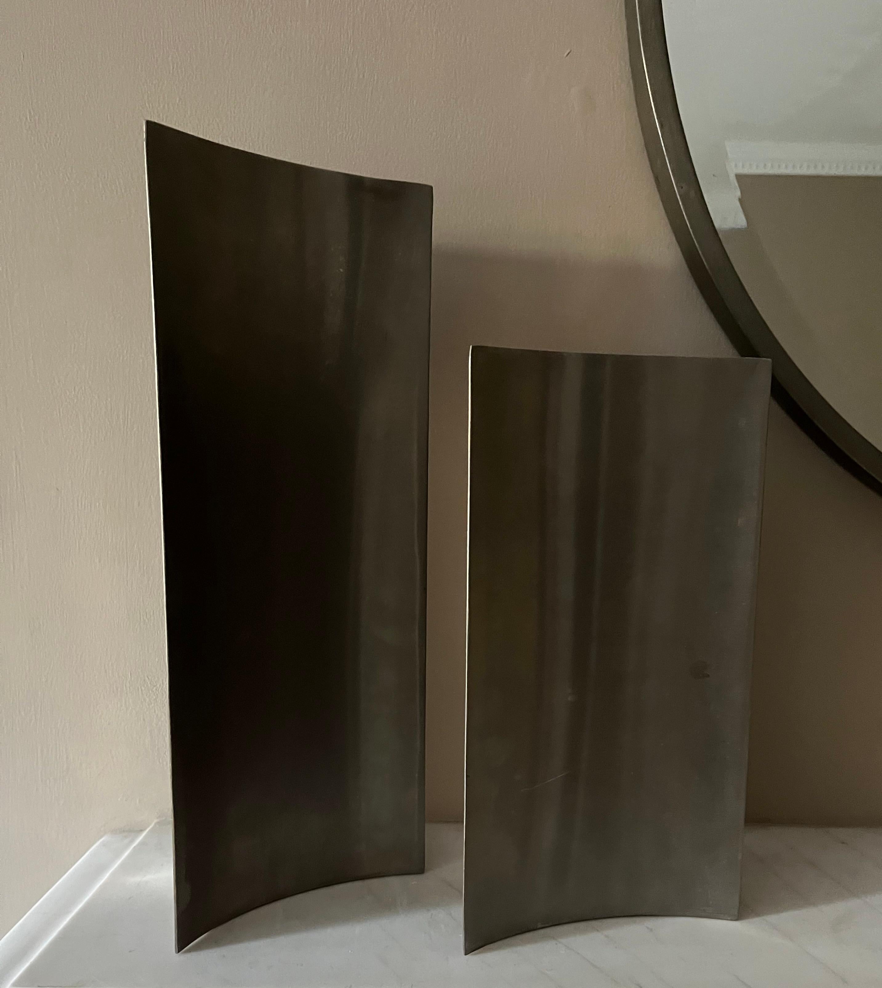 A set of two stylish brushed steel vases by Morbelli Italy. The tallest measure 40cm x 16cm, the smaller one 30cm x 14cm. There are some scratch marks to the steel and minor rust spots but otherwise in good original condition. 