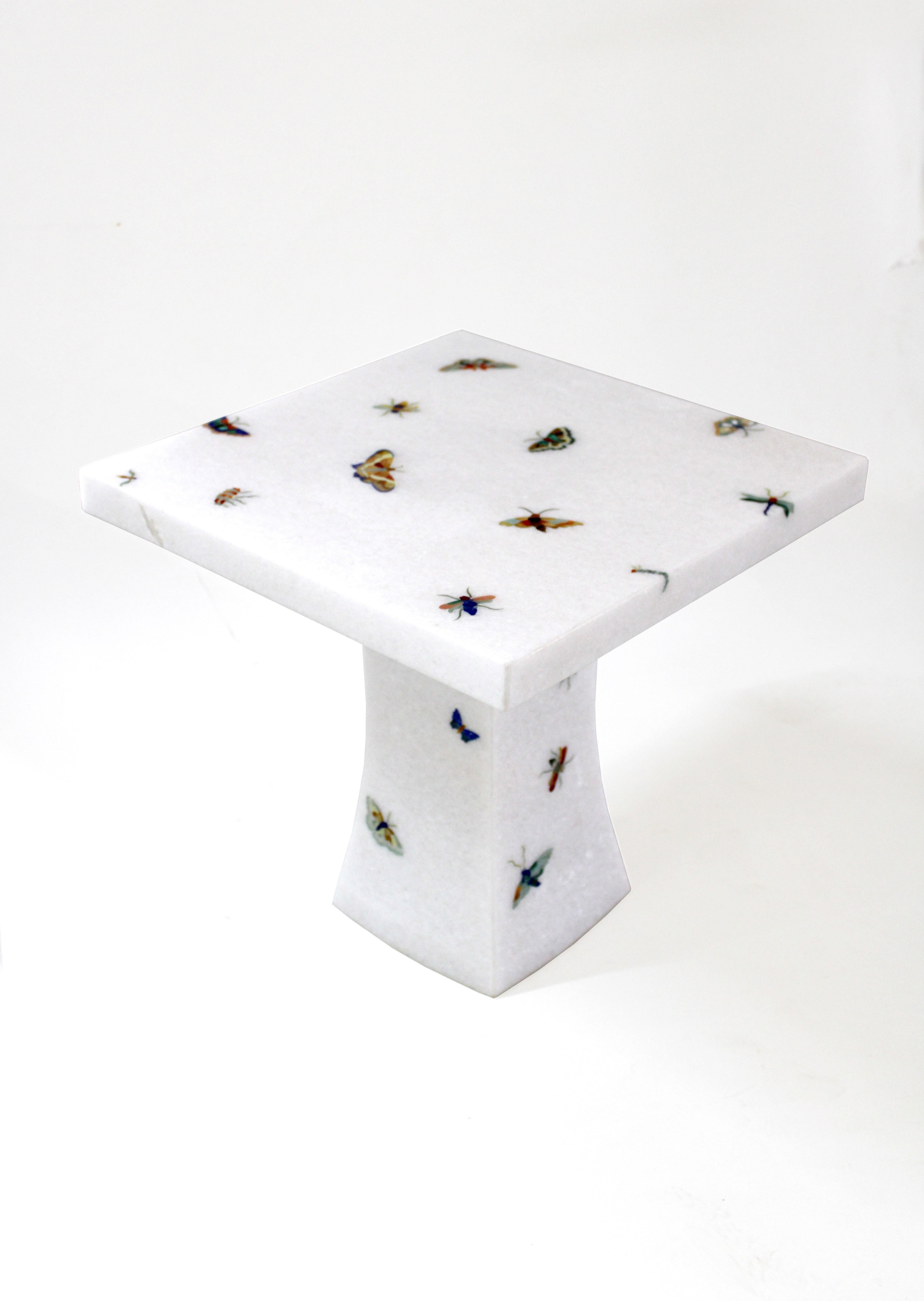 La table papillon fait partie de la collection Ornamenti. Des morceaux d'agate, d'yeux de tigre, de nacre et d'autres pierres semi-précieuses délicatement taillés sont transformés en motifs de papillons et soigneusement incrustés dans la pierre de