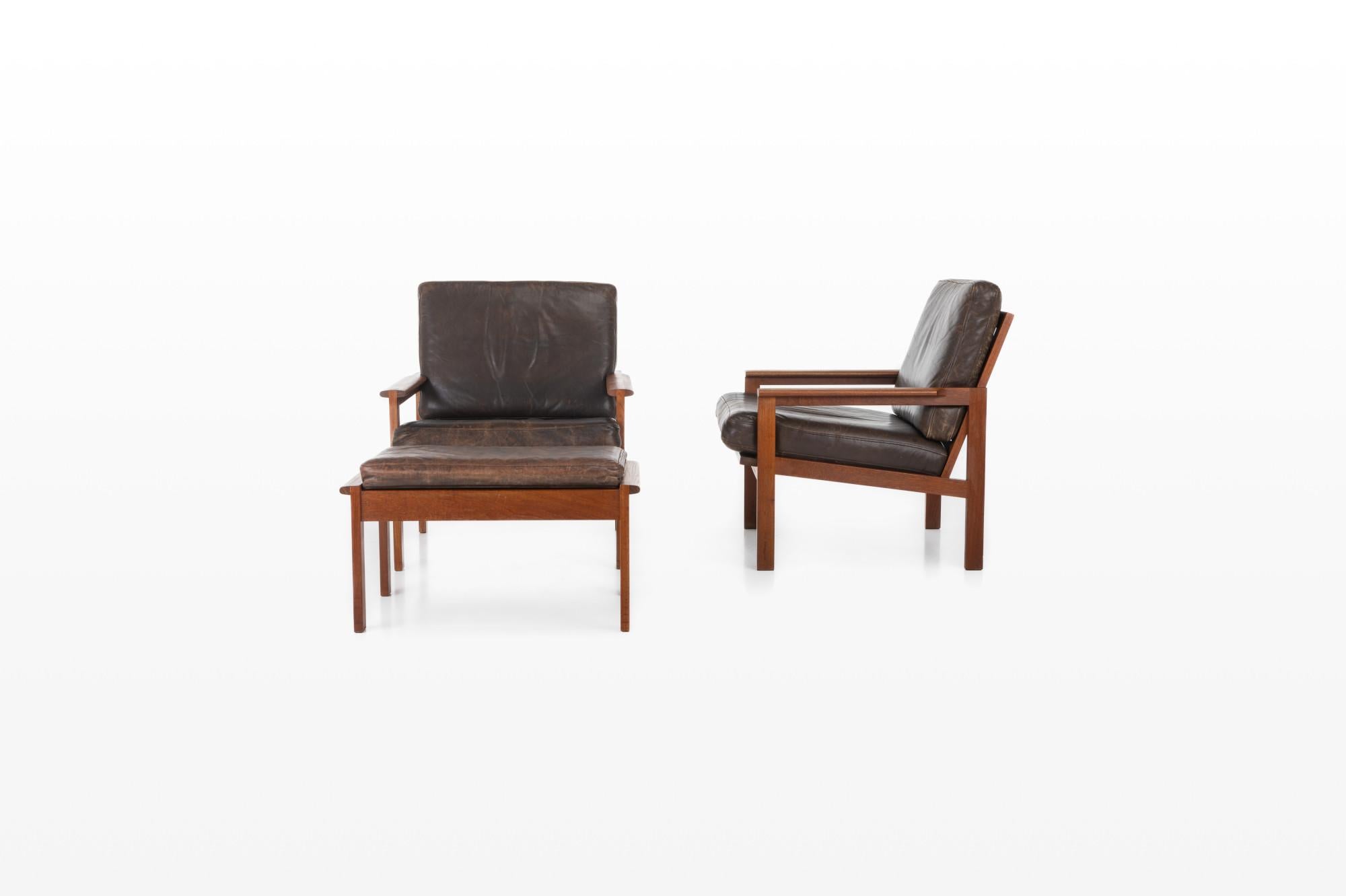 Beautiful set of two 'Capella' easy chairs and hocker in teak designed by Illum Wikkelsø for Niels Eilersen, Denmark 1950s. This set still have the original dark brown leather upholstery with a great patina.

Dimensions:
W: 68 cm
D: 76 cm
H: 77
