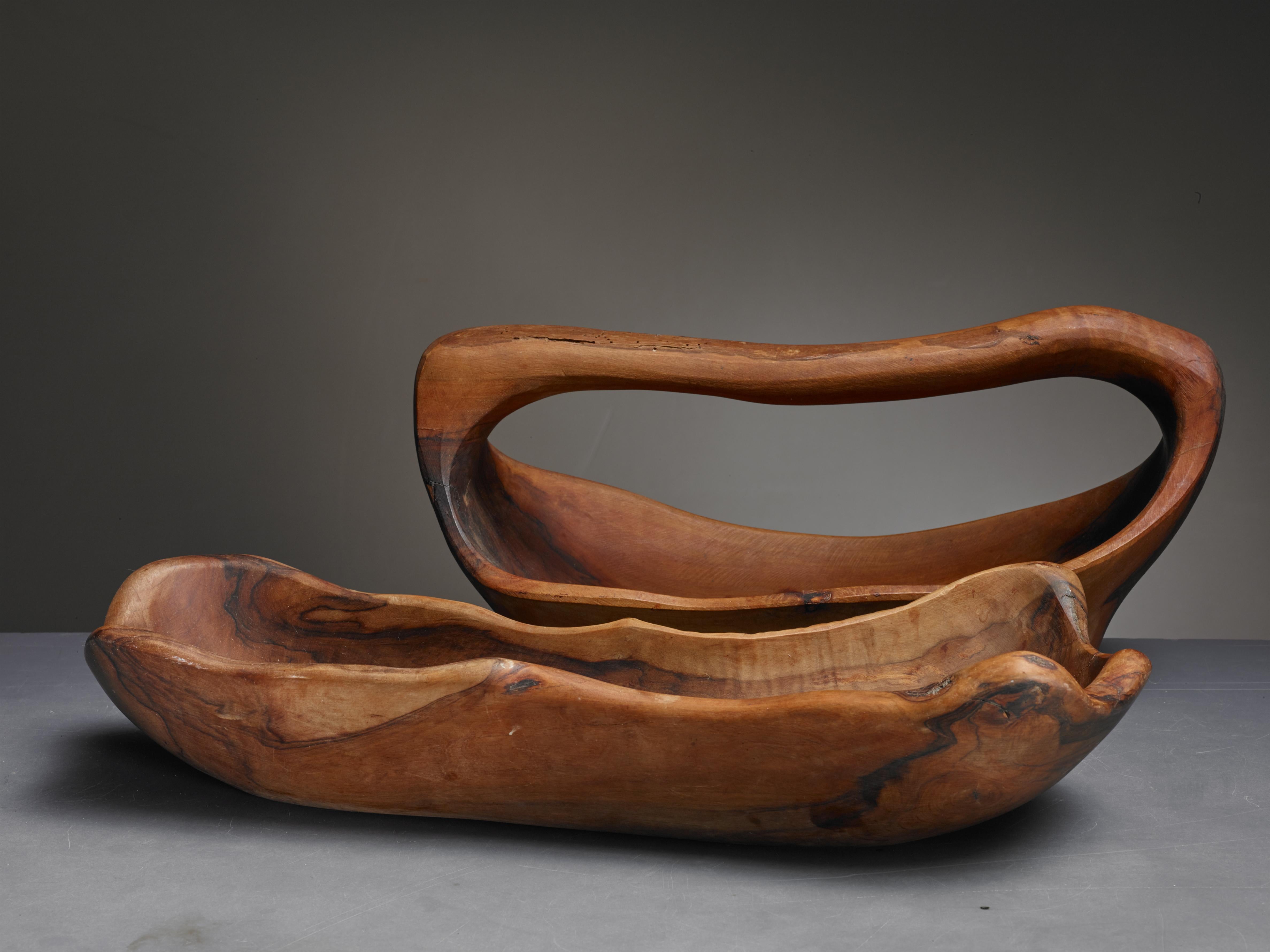 A set of two sculptural, carved wooden bowls from France. Both have a freeform rectangular shape and one has a handle.

The measurements stated are of the bowl without handle. The other one is 34.5 cm (13.5