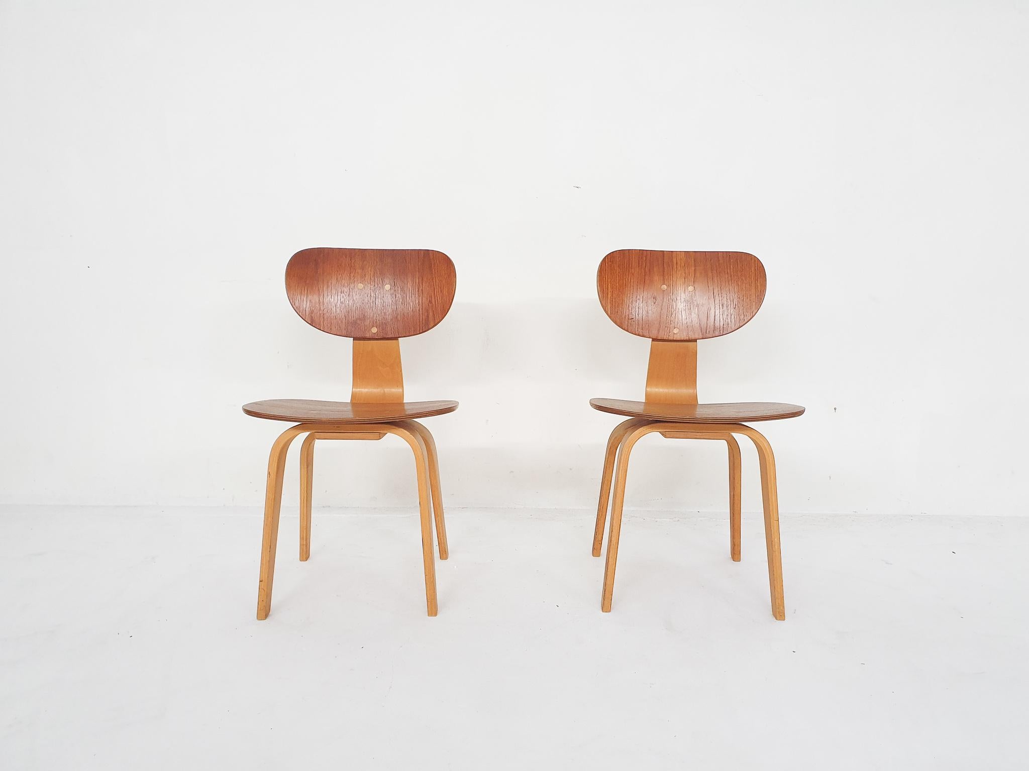 Two plywood dining chairs by Cees Braakman for Pastoe.
One chair has some veneer damage at the back of the back rest.

Cees Braakman
Cees Braakman was a Dutch furniture designer who worked for UMS Pastoe in the midcentury. He designed many beautiful