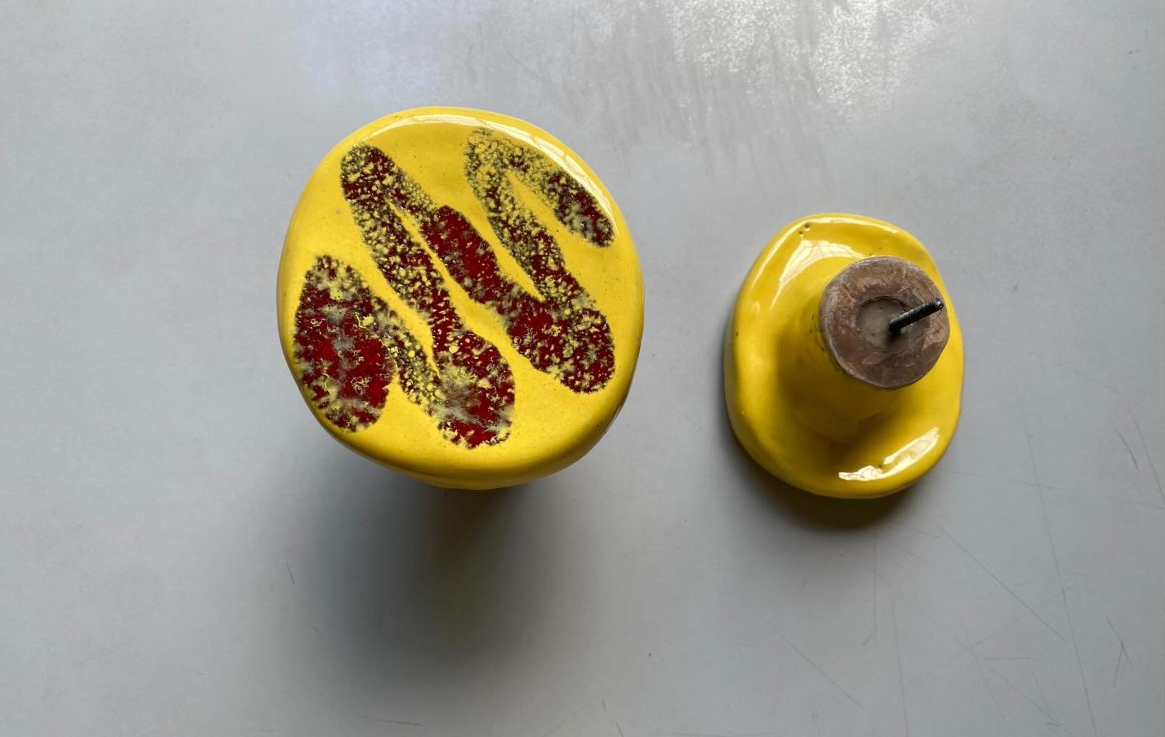 Set of two yellow ceramic coat hangers with red decorations.
The pieces are in excellent condition.