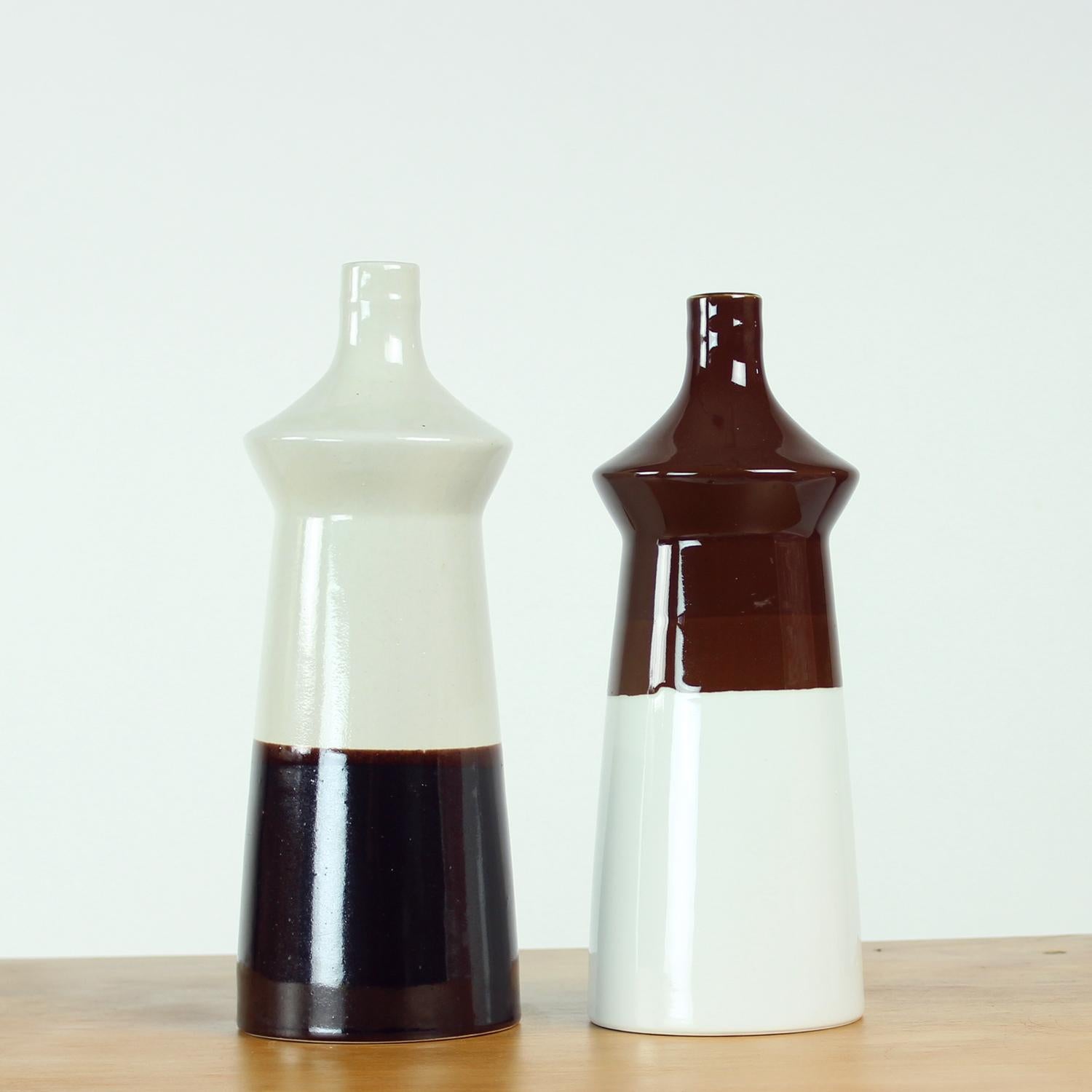 Set di due bellissimi vasi moderni di metà secolo. Realizzati in ceramica pesante, i vasi mostrano un design tipico della metà del secolo. Prodotti negli anni '60, i timbri originali sono ancora visibili sul fondo di entrambi i vasi. Il design è