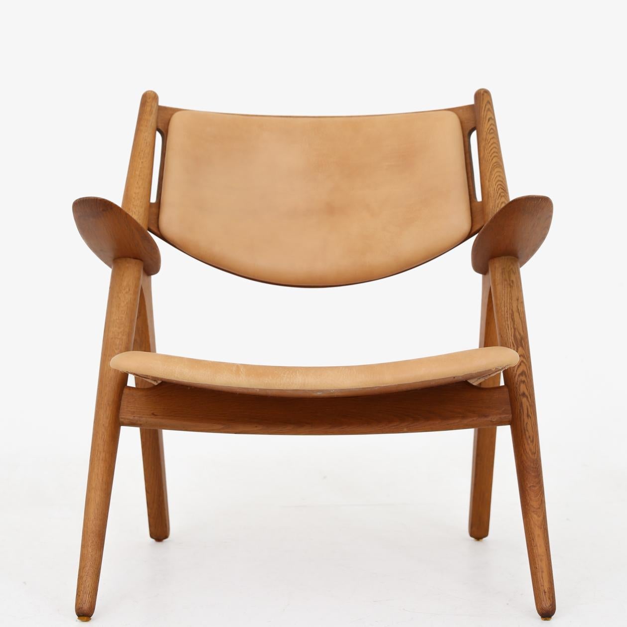 CH 28 - pair of 'Sawbuck' armchairs in patinated oak and natural leather. Designed in 1952. Hans J. Wegner / Carl Hansen.