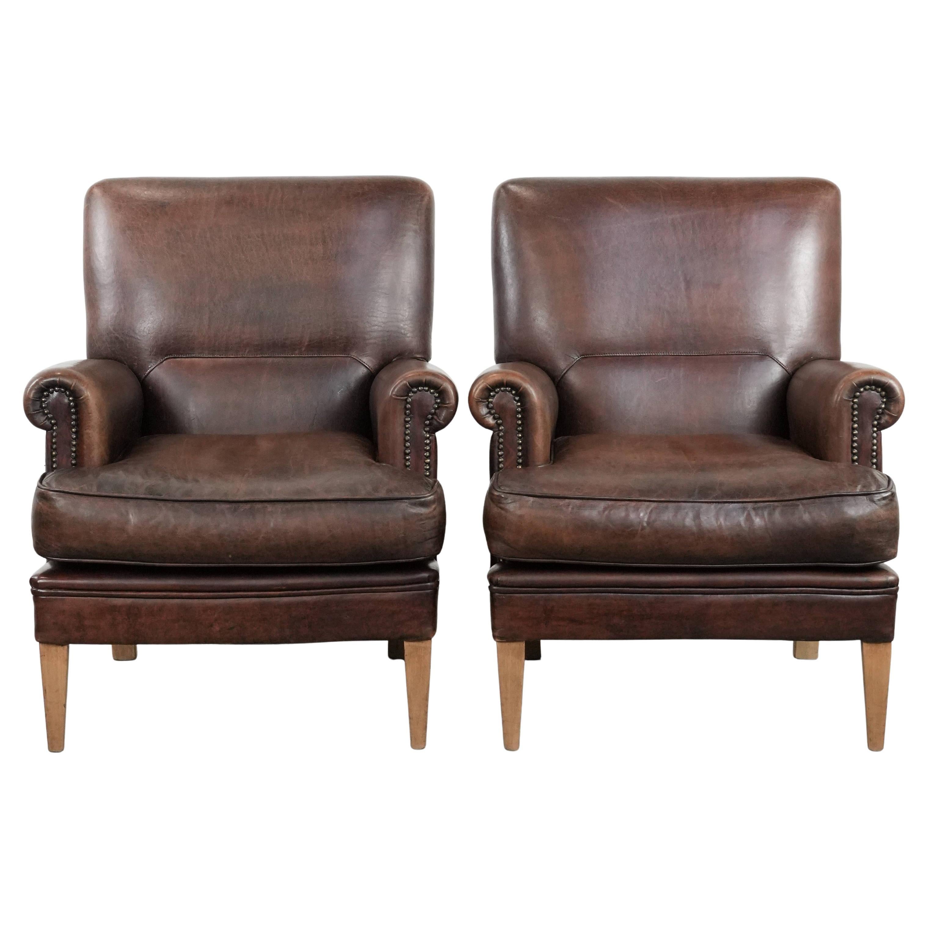 Set of two characterful sheepskin armchairs with a beautiful deep colour For Sale