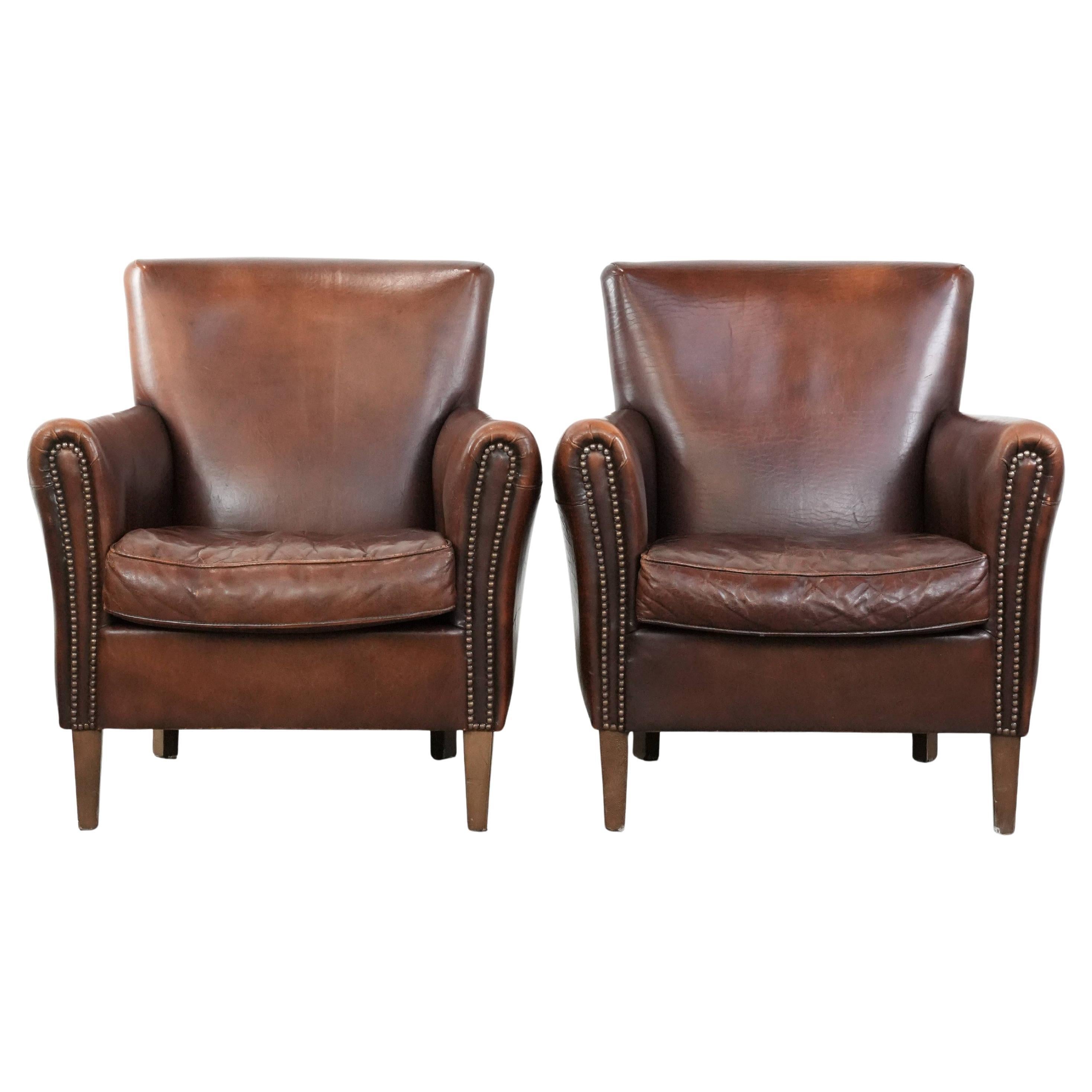Set of two characterful vintage sheepskin leather armchairs