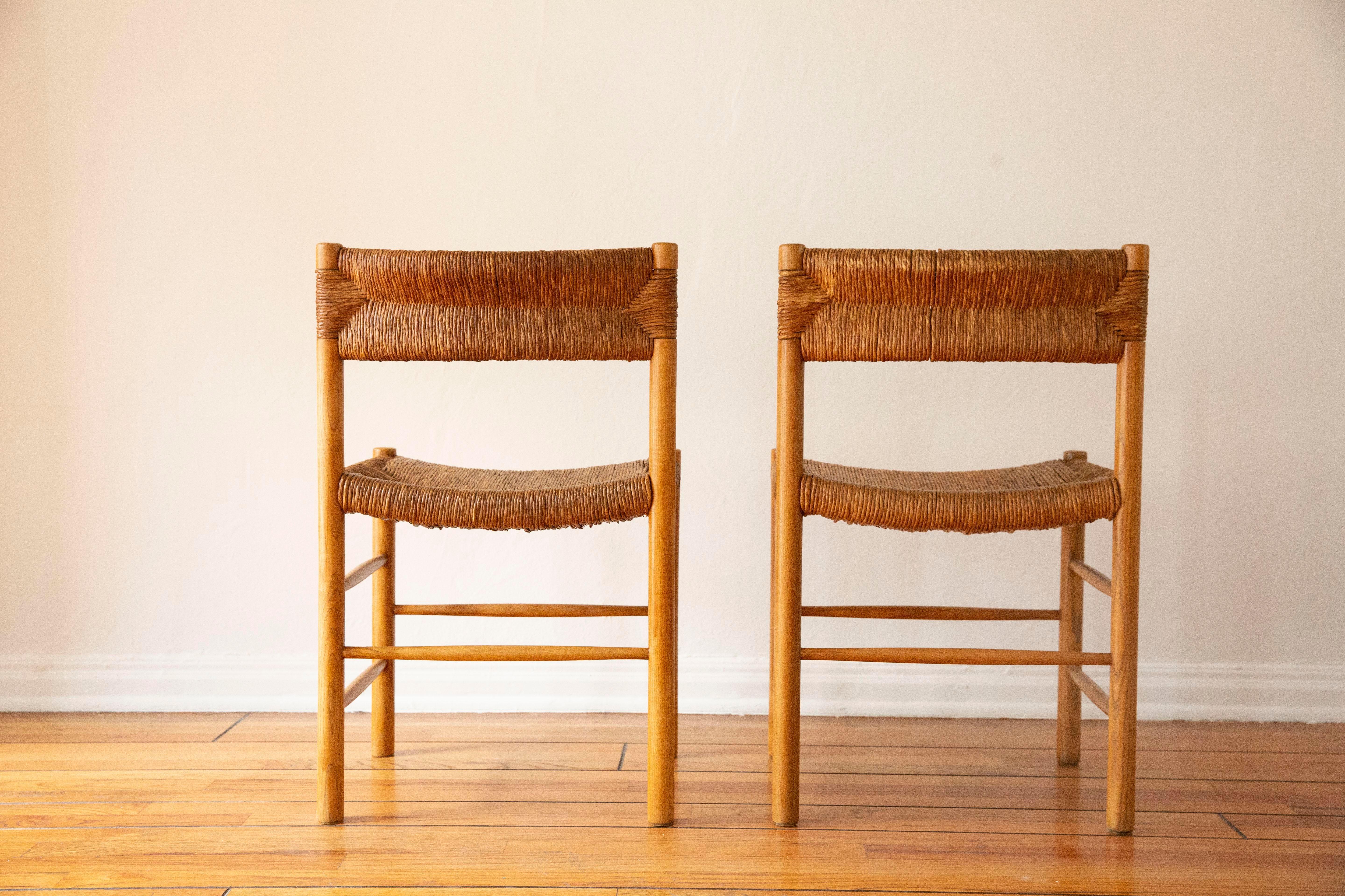 A set of two dining chairs by Charlotte Perriand for Robert Sentou. 