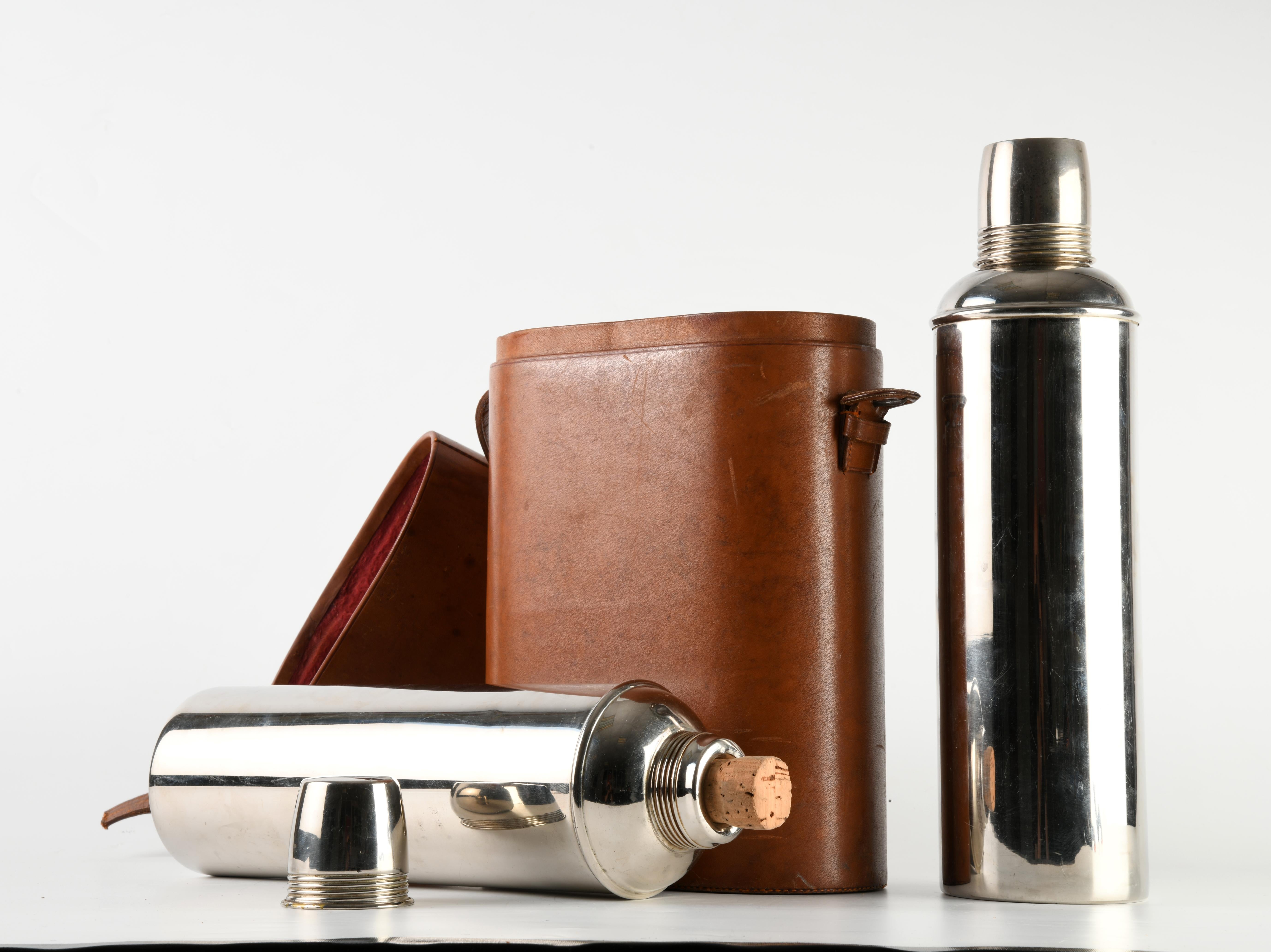 Set of two chrome-plated steel Thermos flasks from the eponymous brand, circa 1930/40. Housed in a velvet-lined leather case with glass interior, closed with cork stoppers and screw-on lids. A difference between the two lids makes it possible to
