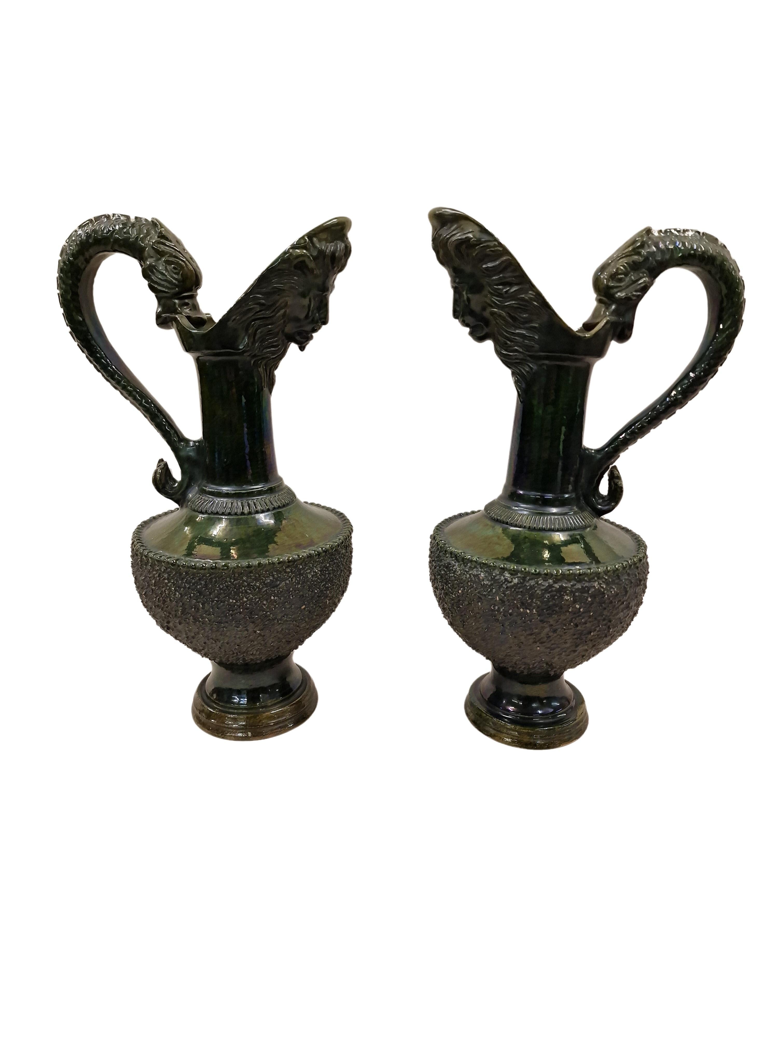 Set of a swivel jug set, in highly elaborate quality, made around 1880 in England.

The jugs have a round base which opens into a very bulbous body which then flows into a very upturned neck and an outlet with a lion's face. The handles are also