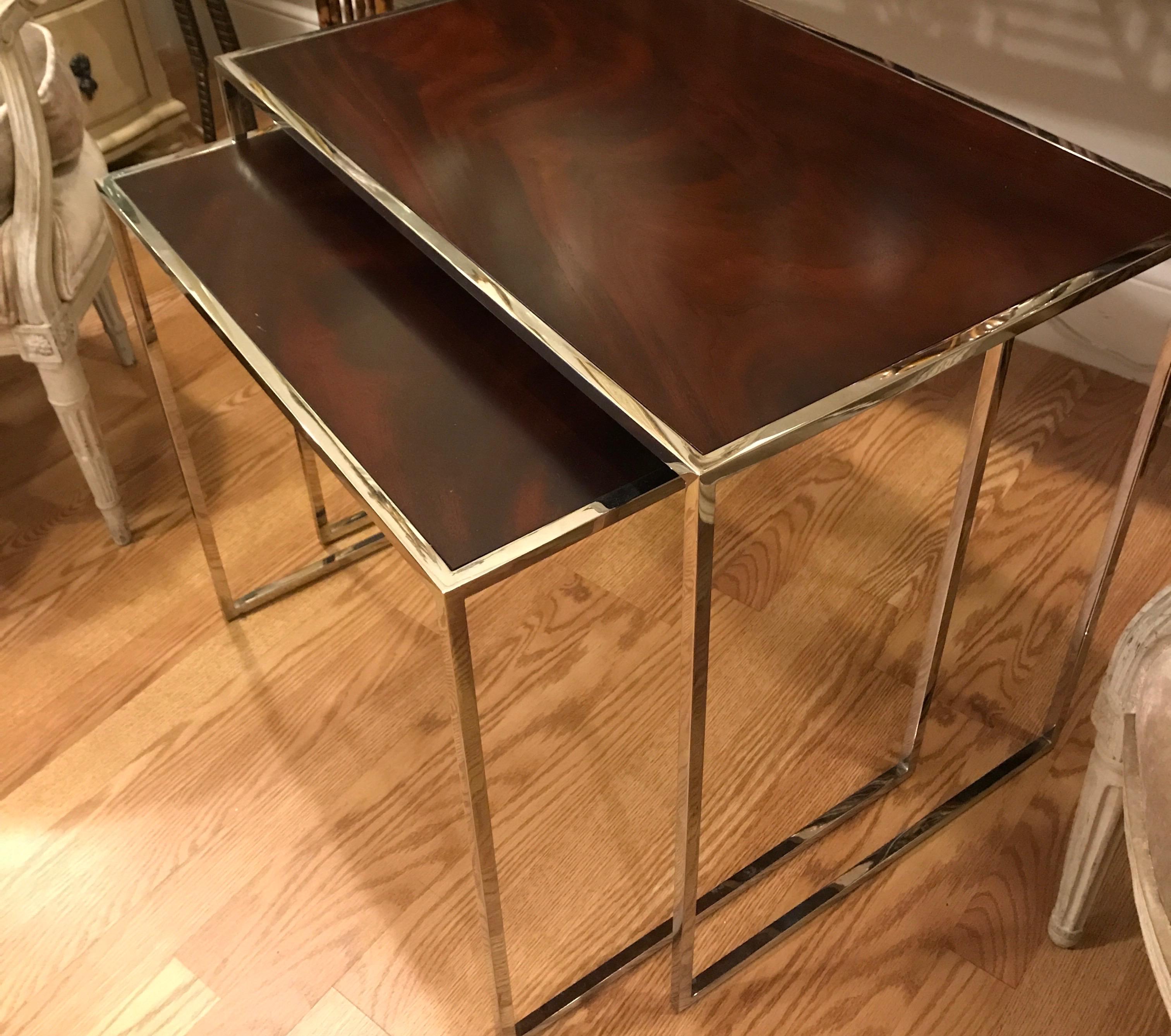 Set of two polished chrome and wood stacking tables.