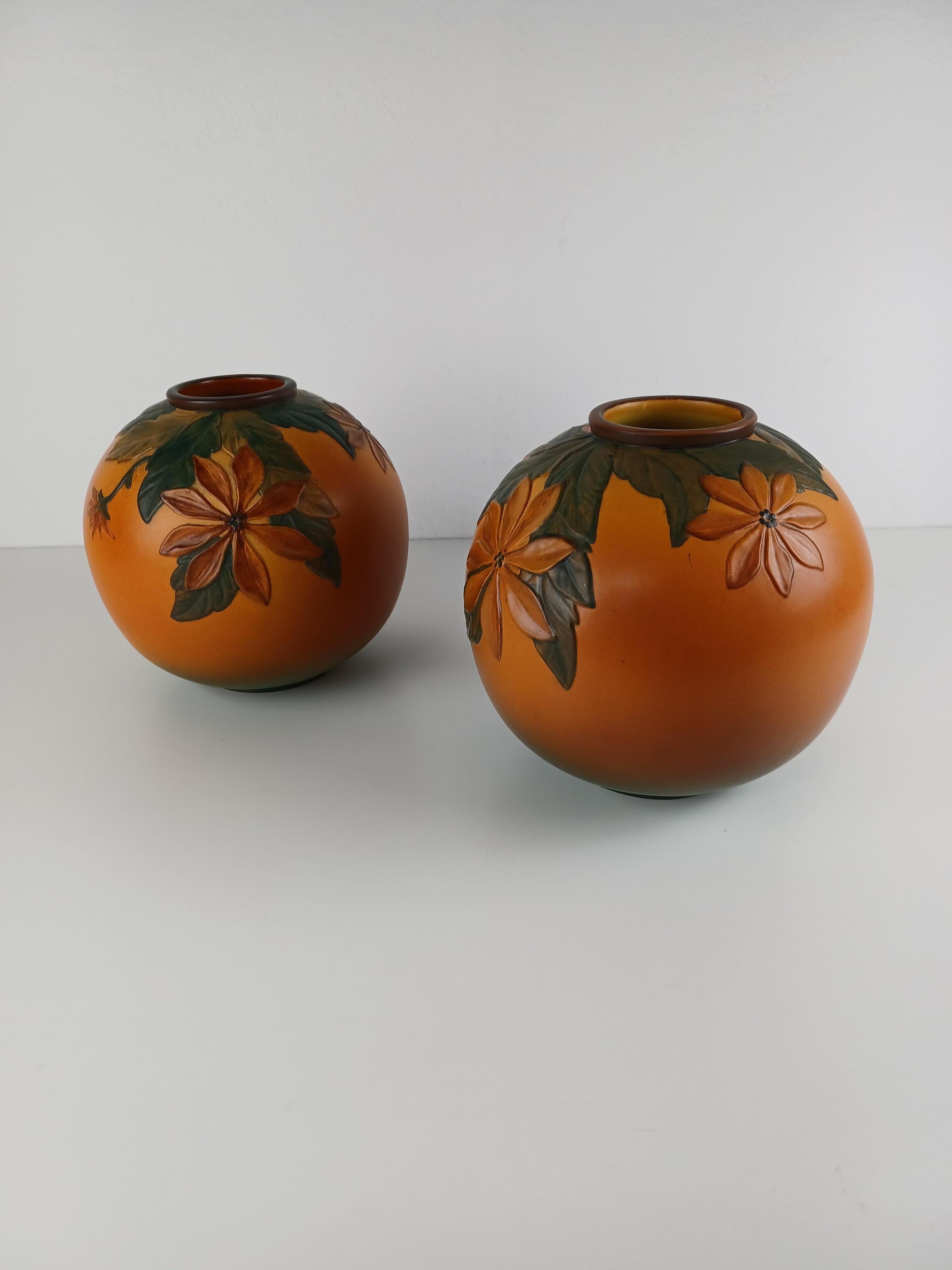 Ensemble de deux vases art nouveau danois décorés de fleurs, faits à la main par P. Ipsen Enke

Les vases Art nouveau ont été conçus par Axel Sørensen en 1939 et présentent des fleurs et des feuilles vivantes très bien réalisées. Les vases ont été