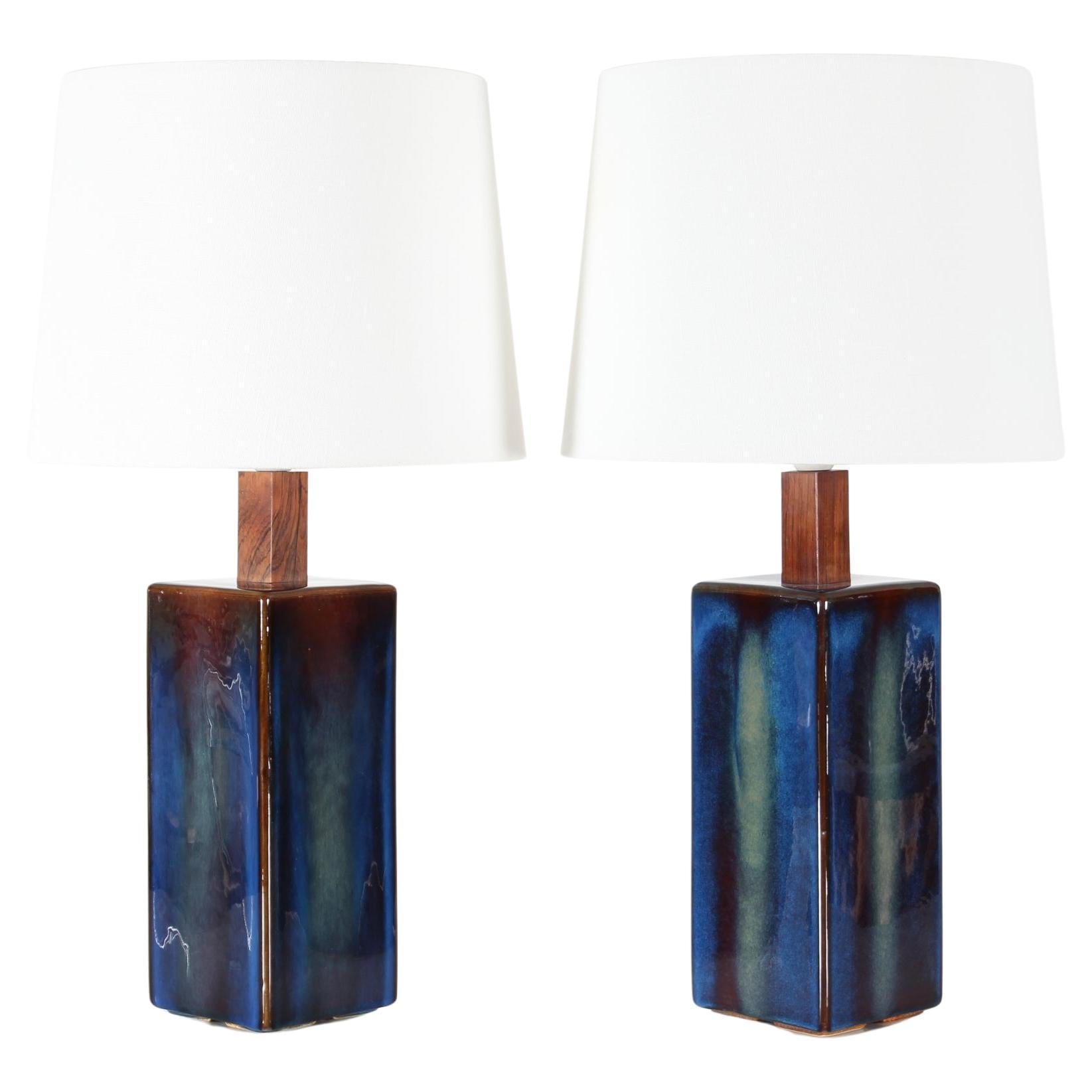 Set of two tall sculptural ceramic table lamps made by Søholm Stentøj in Denmark. circa 1960s.

Decorated with midnight blue glaze with a twist of green turning into dark brown at the edges. 
The socket is fitted to a delicate square block of wood